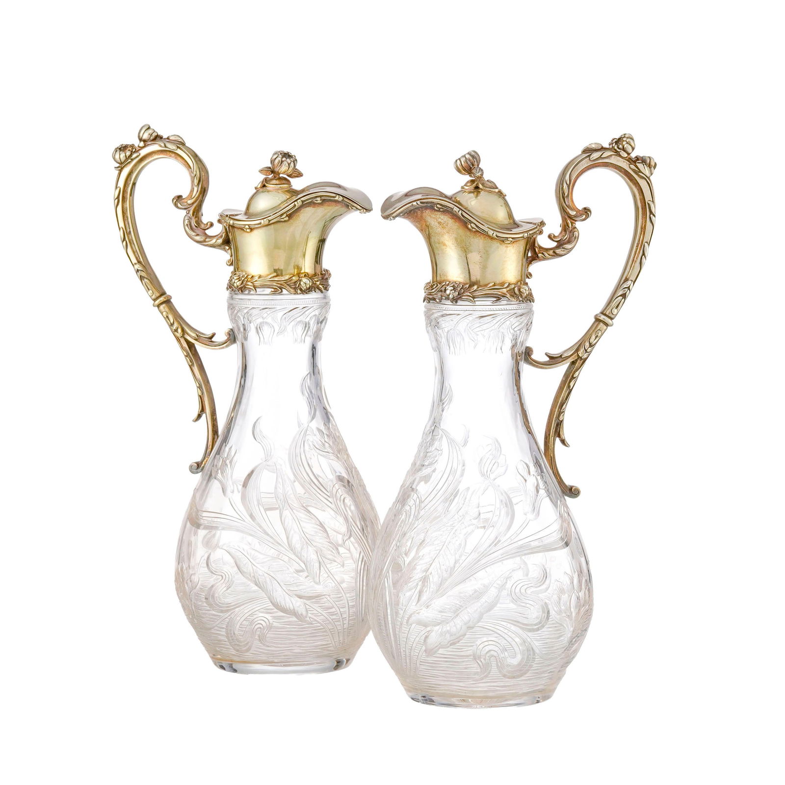 Paire d'aiguières en vermeil Sterling et verre, XXe s., à décor floral et vég: Paire d'aiguières en vermeil Sterling et verre, XXe s., à décor floral et végétal, h. 32,5 cm Provenance: Château de Bellerive, Collonges-Bellerive, Genève Condition