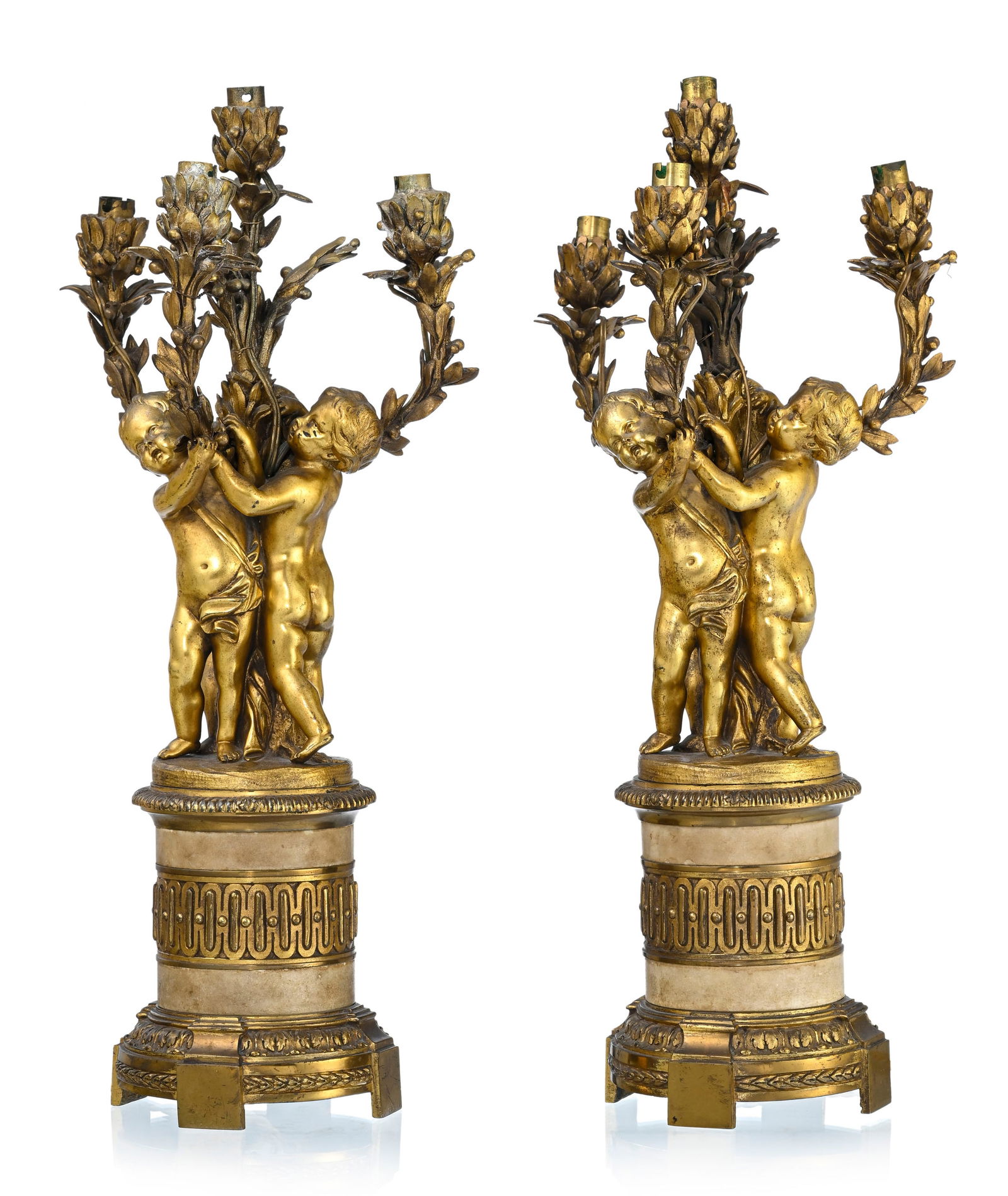Paire de candélabres d'époque Napoléon III, en bronze ciselé et doré, à: Paire de candélabres d'époque Napoléon III, en bronze ciselé et doré, à décor de putti supportant des bras de lumière, quatre feux, base cylindrique ornée