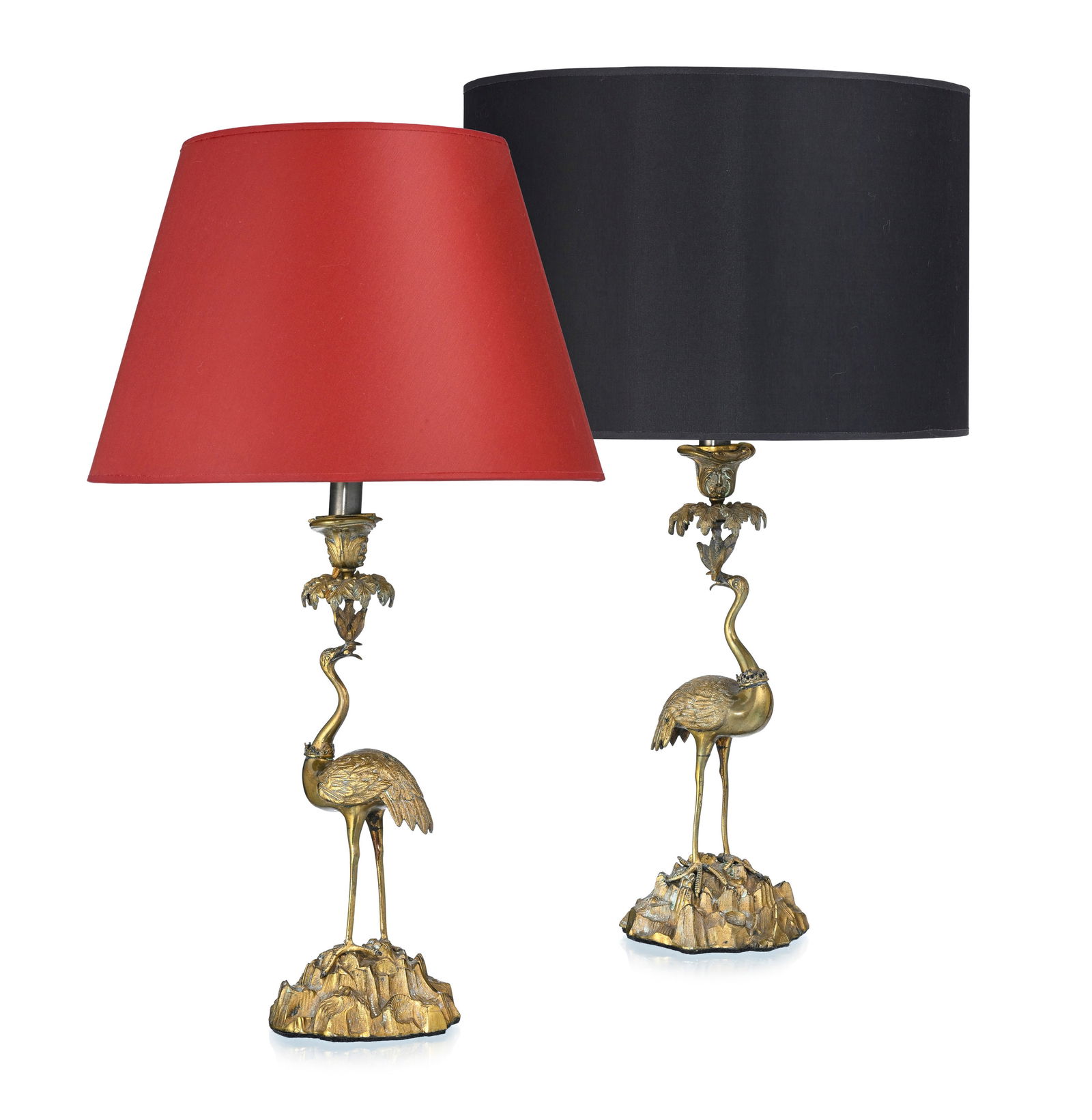 Paire de lampes de salon, XXe s., en laiton et métal doré, figurant un échassier tena: Paire de lampes de salon, XXe s., en laiton et métal doré, figurant un échassier tenant une branche, base simulant des roches, abat-jour en tissu noir et rouge, h. avec l'abat-jour: 67