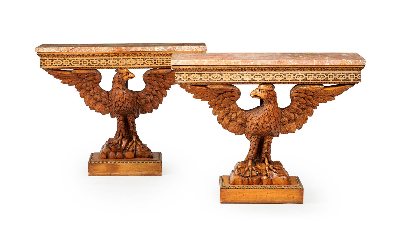 Paire de consoles de style Regency, XXe s., en bois naturel sculpté à décor d'un aigl: Paire de consoles de style Regency, XXe s., en bois naturel sculpté à décor d'un aigle aux ailes déployées, plateau en marbre rose, 85x110x40 cm Conditionusures au vernis