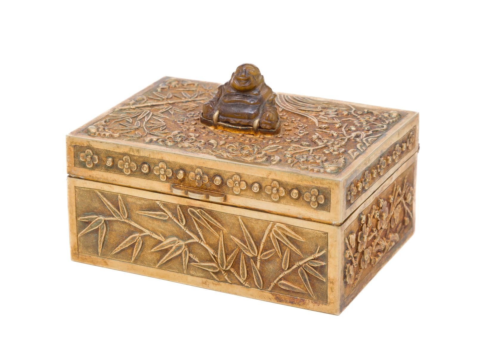 Boîte rectangulaire en argent doré, surmontée d'un Bouddha en œil de tigre, Chin: Boîte rectangulaire en argent doré, surmontée d'un Bouddha en œil de tigre, Chine, XXe s., décor de divers arbres et fleurs, poinçon SILVER sous la base, 9x6,5x4 cm A