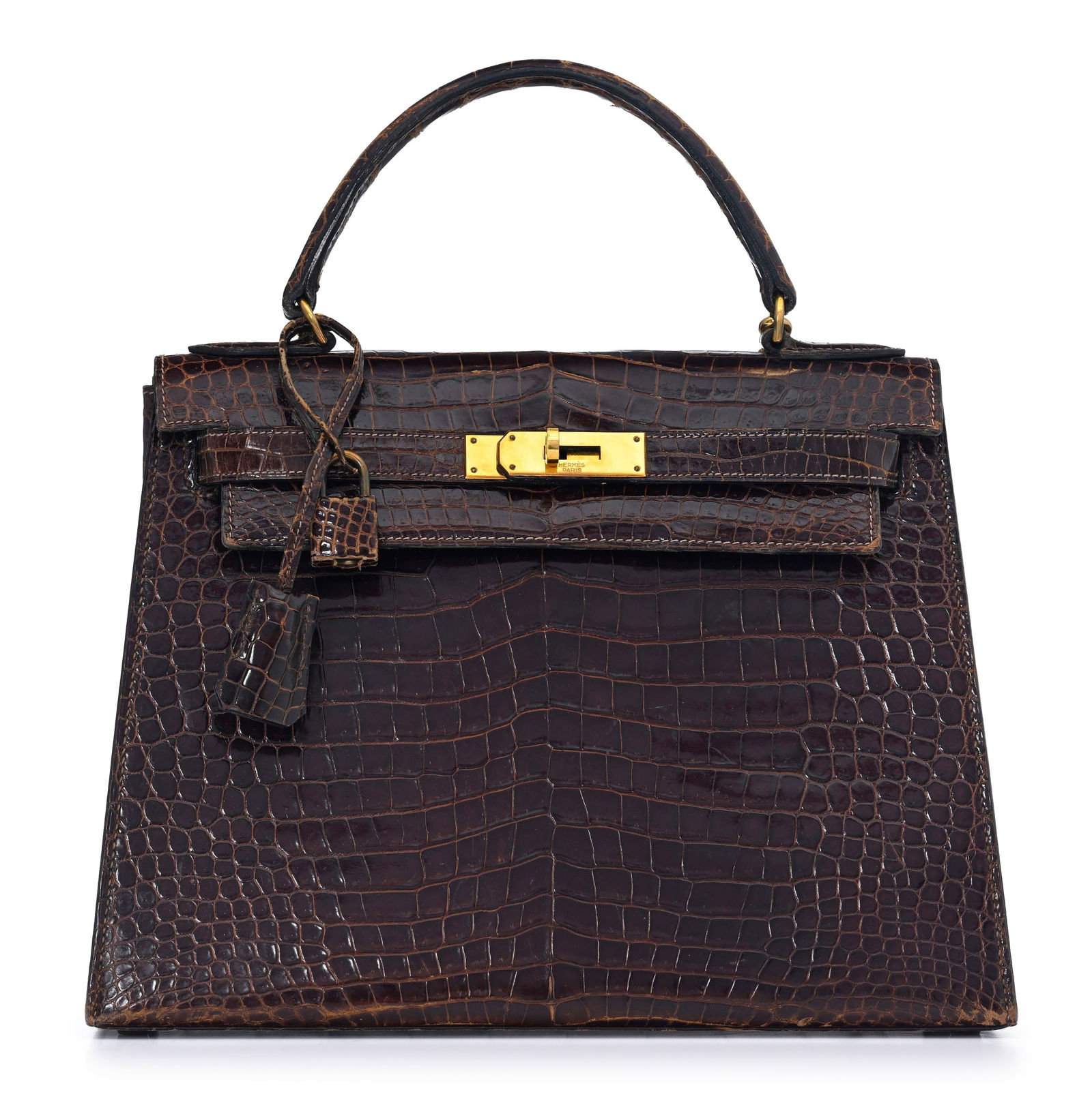 Hermès, sac Kelly 28 en crocodile Havane, année 1973, tirette et clochette avec deux clefs: Hermès, sac Kelly 28 en crocodile Havane, année 1973, tirette et clochette avec deux clefs et cadenas, bandoulière, housse, 21x28 cm Veuillez noter que pour le transport hors de