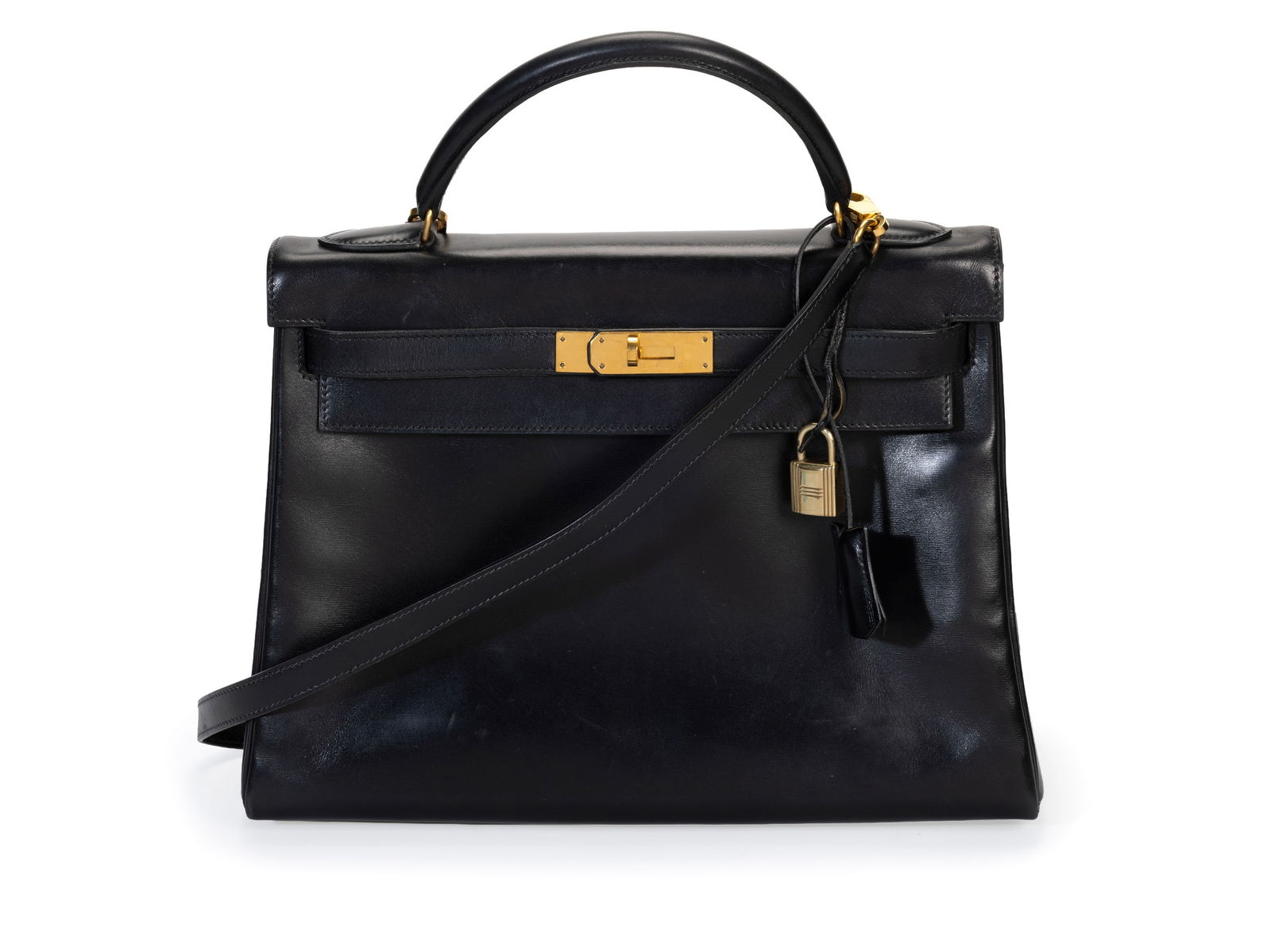 Hermès, sac Kelly 32 Retourné en box noir, année 1992, tirette, clochette, 2 clefs, c: Hermès, sac Kelly 32 Retourné en box noir, année 1992, tirette, clochette, 2 clefs, cadenas, bandoulière, boîte, 23x32 cm ConditionTrès bon état de conservation Peu