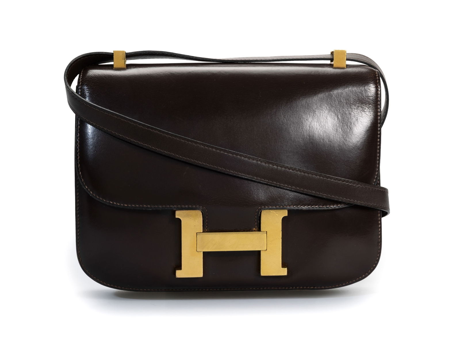 Hermès, sac Constance en cuir de box chocolat, année 1971, bouclerie plaquée or, hous: Hermès, sac Constance en cuir de box chocolat, année 1971, bouclerie plaquée or, housse, 18x23 cm ConditionTrès bon état de conservation pour son âge Usures à la