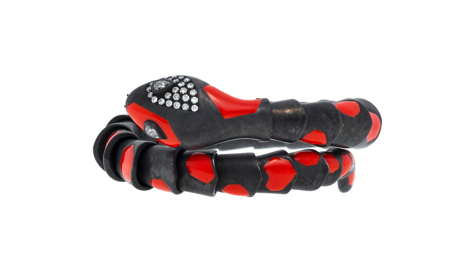 Bracelet flexible figurant un serpent en acier noirci s'enroulant autour du poignet tacheté d'&: Bracelet flexible figurant un serpent en acier noirci s'enroulant autour du poignet tacheté d'émail rouge, la tête sertie de diamants taille poire et brillant, circ. environ 14-15