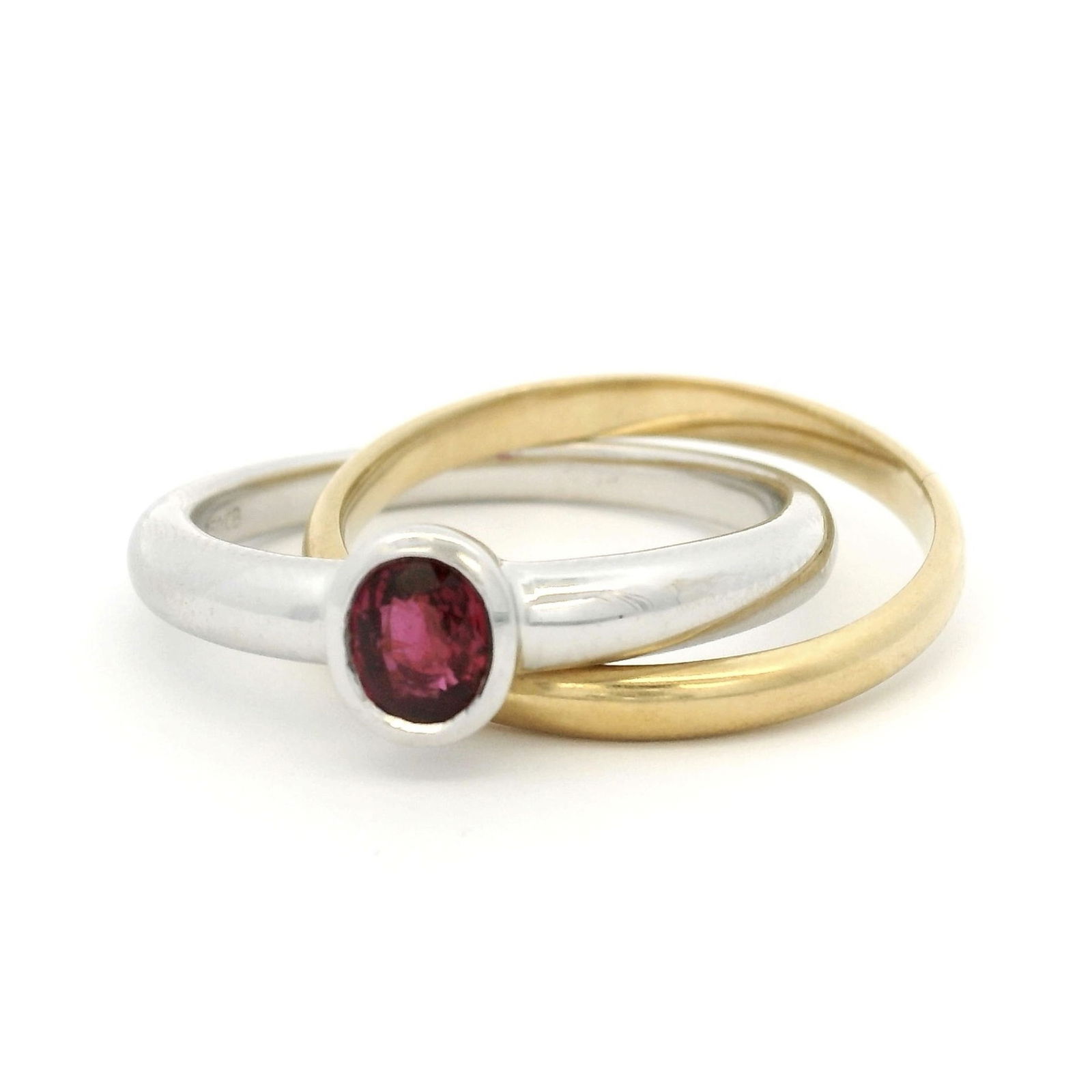 Bucherer, bague formée de deux anneaux en or gris et jaune 750, l'un serti d'un rubis taille ov: Bucherer, bague formée de deux anneaux en or gris et jaune 750, l'un serti d'un rubis taille ovale, signée, doigt 54-14, 5g ConditionBon état de conservation général.