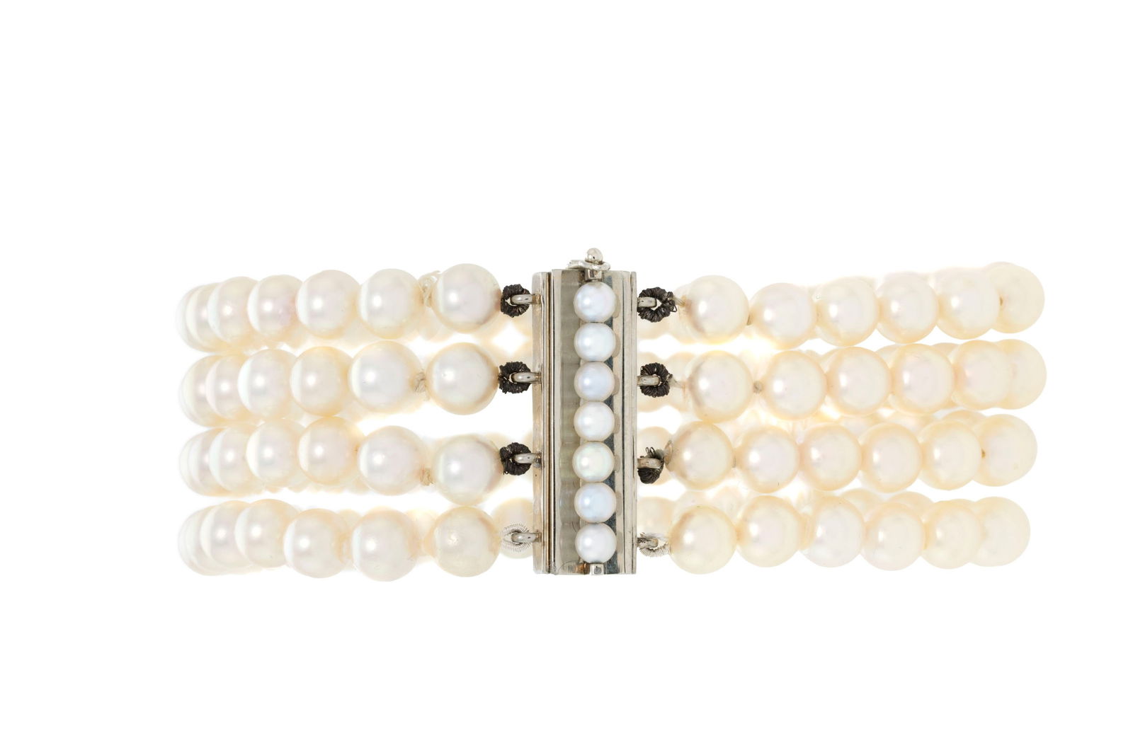 Bracelet 4 rangs de perles de culture blanches, fermoir en or gris 750 orné d'une ligne de perl: Bracelet 4 rangs de perles de culture blanches, fermoir en or gris 750 orné d'une ligne de perles de culture plus petites, long. 21 cm ConditionBon état de conservation général. 