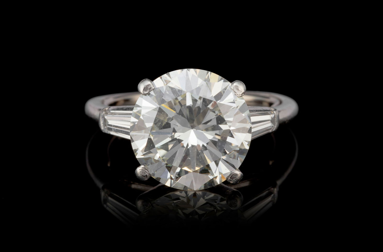 Solitaire platine, serti d'un diamant taille brillant (env. 5.3 ct) épaulé de diamants tai: Solitaire platine, serti d'un diamant taille brillant (env. 5.3 ct) épaulé de diamants taille baguette-trapèze, doigt 50-15 ConditionBon état de conservation général