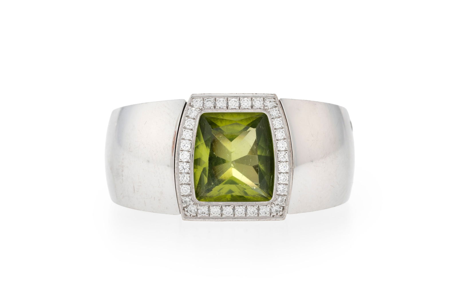 Cartier, bague or gris 750 sertie d'un péridot forme coussin entouré de diamants taille br: Cartier, bague or gris 750 sertie d'un péridot forme coussin entouré de diamants taille brillant, signé, numéroté NW3170, doigt 55-15, 21g ConditionBon état de