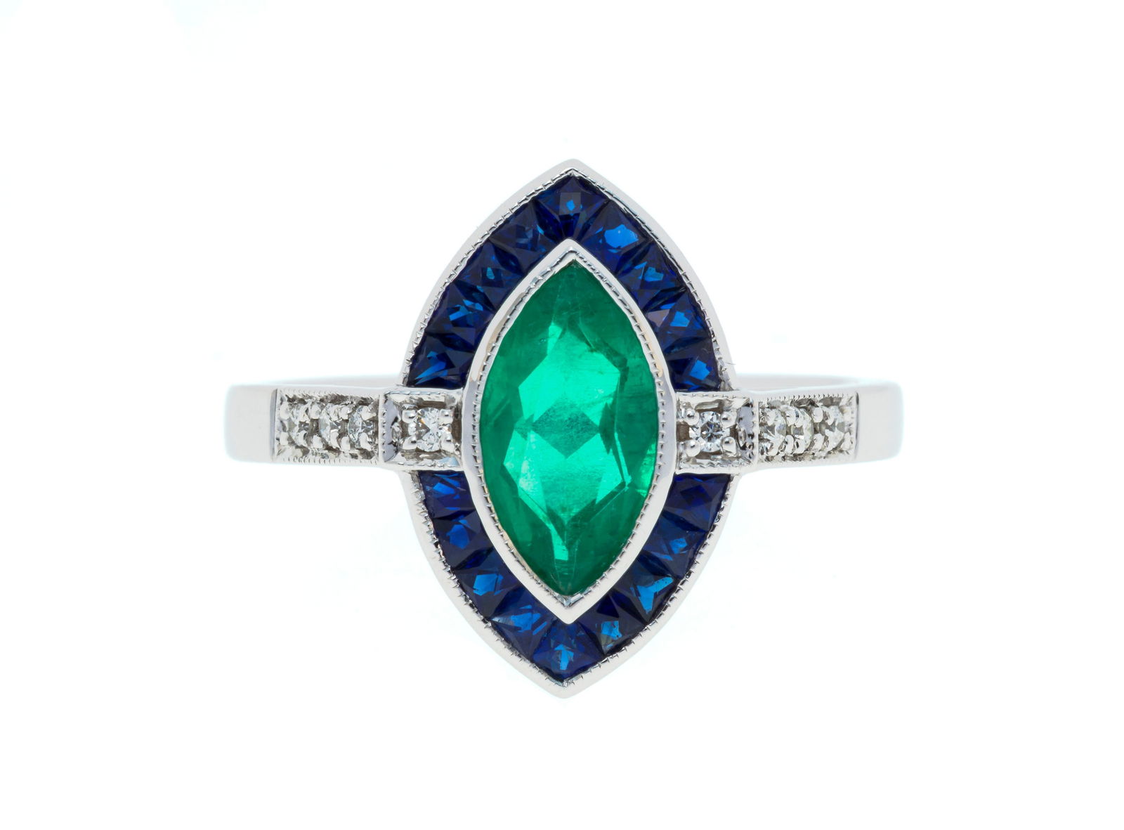 Bague or gris 750 ornée d'une émeraude taille marquise entourée de saphirs calibr: Bague or gris 750 ornée d'une émeraude taille marquise entourée de saphirs calibrés et de diamants taille brillant, doigt 13-53 Condition Très bon état général.