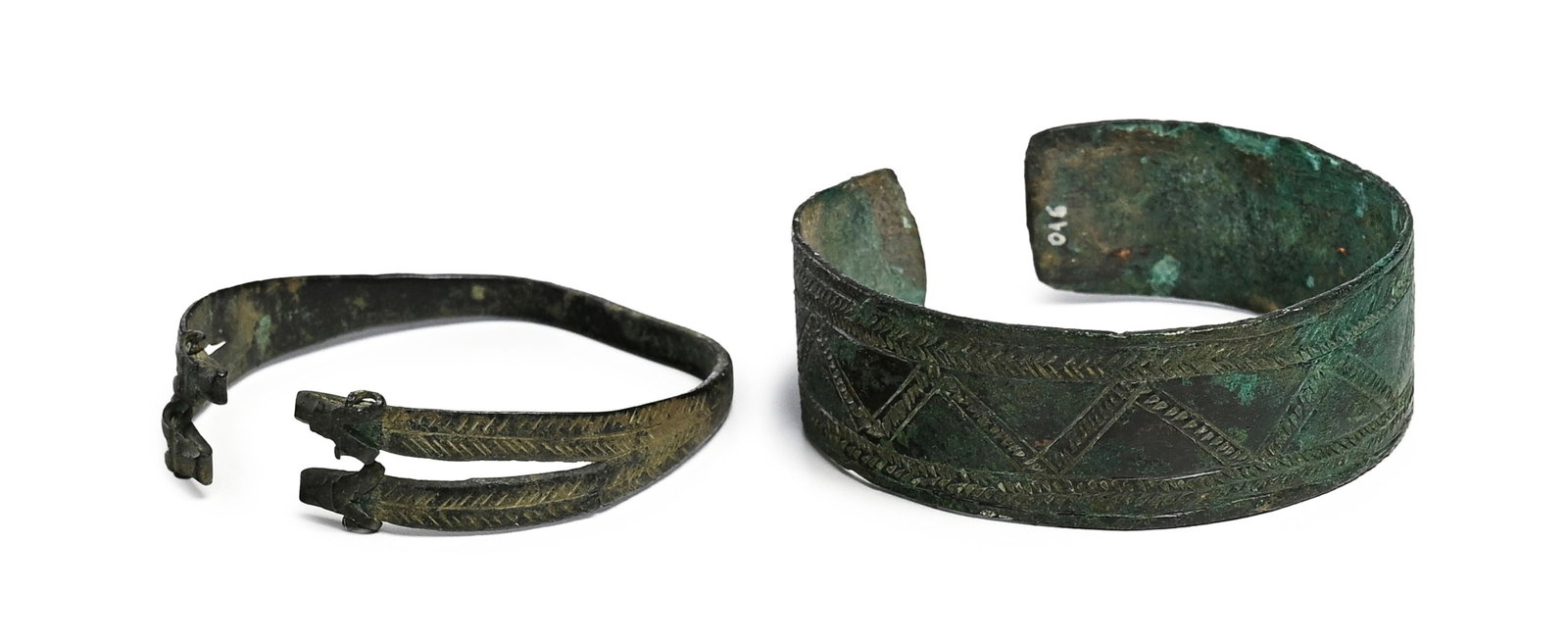 2 bracelets en bronze, Luristan, 1100 - 800 av. J.-C., l'un à décor de frises géom: 2 bracelets en bronze, Luristan, 1100 - 800 av. J.-C., l'un à décor de frises géométriques remplies de traits et chevrons, l'autre finissant en quatre tête de bouquetins,