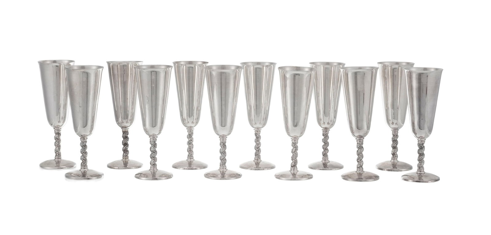 Suite de 12 flûtes à champagne en argent égyptien, XXe s., le fût torsadé &: Suite de 12 flûtes à champagne en argent égyptien, XXe s., le fût torsadé à motif de vigne, h. 18 cm, 2120g Condition choc sur la base d'une flûte