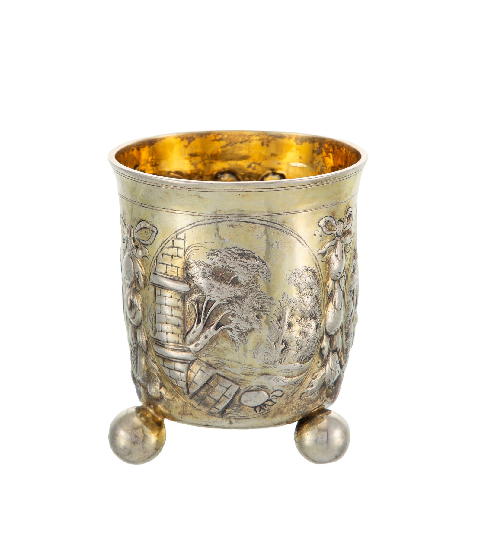 Timbale tripode en vermeil, Nuremberg, XVIIe s., à décor repoussé de paysage et archi: Timbale tripode en vermeil, Nuremberg, XVIIe s., à décor repoussé de paysage et architecture, les pieds boules, h. 10,5 cm, 145g Condition choc sur un pied boule