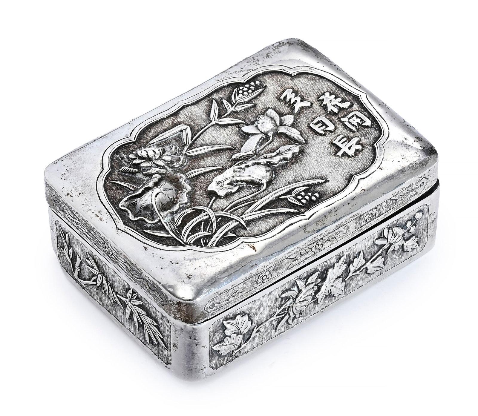 Boîte rectangulaire en argent, Chine, XXe s., décor de diverses fleurs en relief et inscri: Boîte rectangulaire en argent, Chine, XXe s., décor de diverses fleurs en relief et inscription sur fond amati, poinçon 珠海 (Zhu Hai) sous la base, 11x8x4 cm, 190g (coups)
