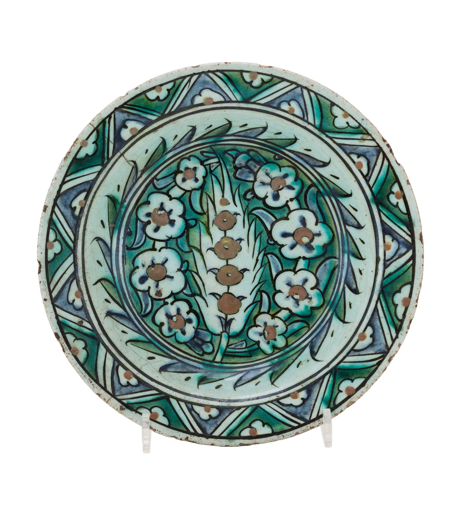 Plat creux en céramique à polychromie tricolore, Iznik, XVIIe s., décor central de cy: Plat creux en céramique à polychromie tricolore, Iznik, XVIIe s., décor central de cyprès et d'œillets, marli décoré d'une frise géométrique et florale, di