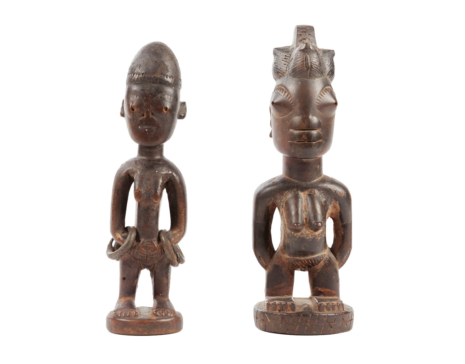 2 statuettes féminines Ibedji Yoruba, bois à patine brun foncé et croûteuse dans: 2 statuettes féminines Ibedji Yoruba, bois à patine brun foncé et croûteuse dans les creux, une ornée de bracelets en fer forgé, Nigéria, h. 25 et 27 cm Collection