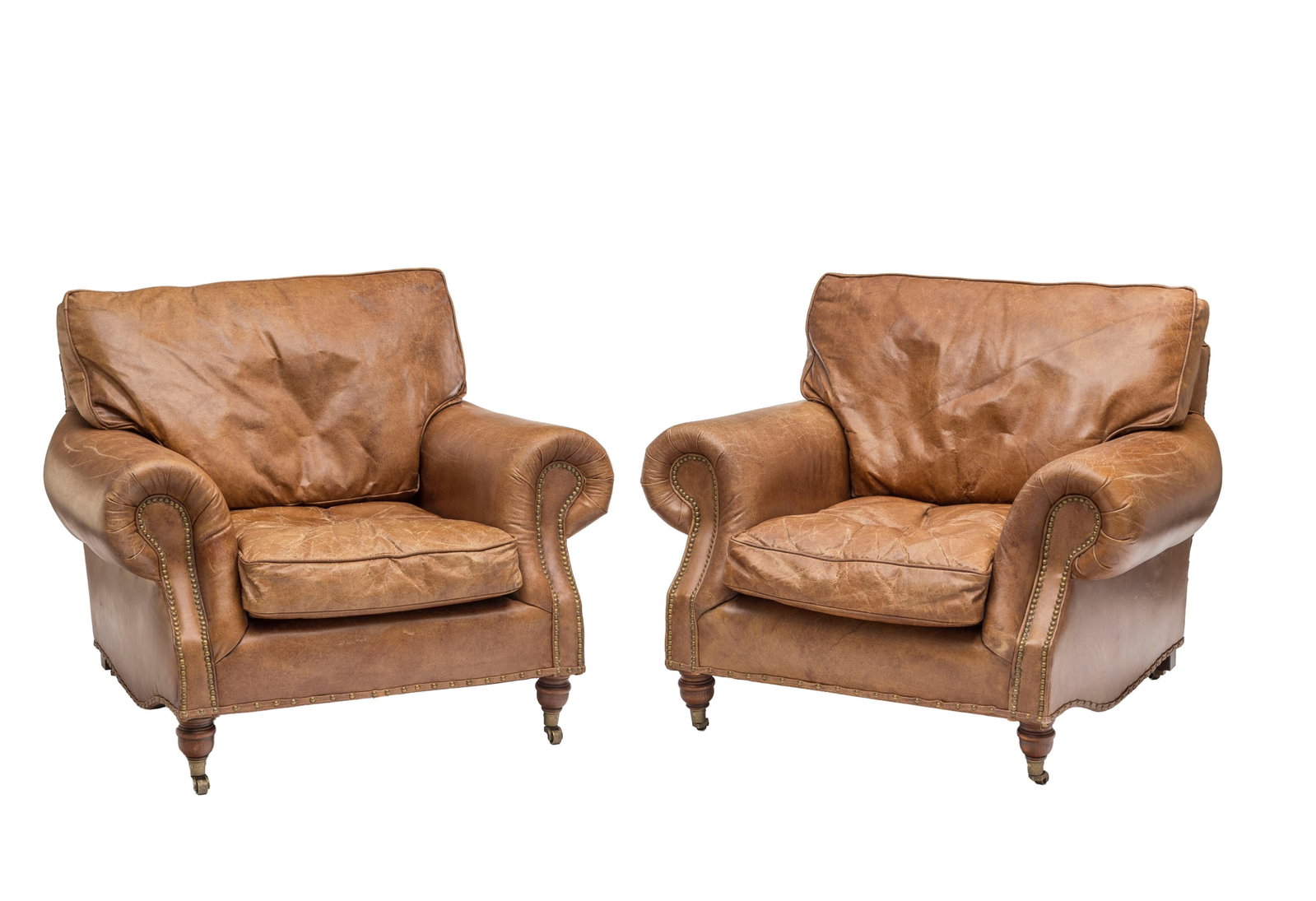 Paire de larges fauteuils, XXIe s., en similicuir marron, pieds en bois naturel reposant sur des rou: Paire de larges fauteuils, XXIe s., en similicuir marron, pieds en bois naturel reposant sur des roulettes en laiton Condition plissures et usures sur la garniture