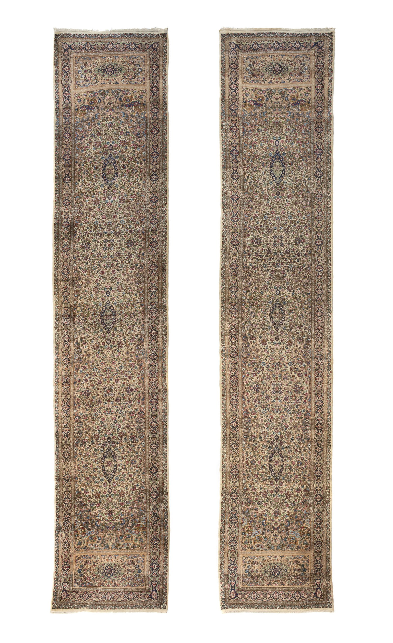 Paire de tapis de passage Kerman, Iran, 1ère moitié du XXe s., à décor de mé: Paire de tapis de passage Kerman, Iran, 1ère moitié du XXe s., à décor de médaillons flanqués de rinceaux fleuris sur fond ivoire, 117x559 cm et 115x572 cm