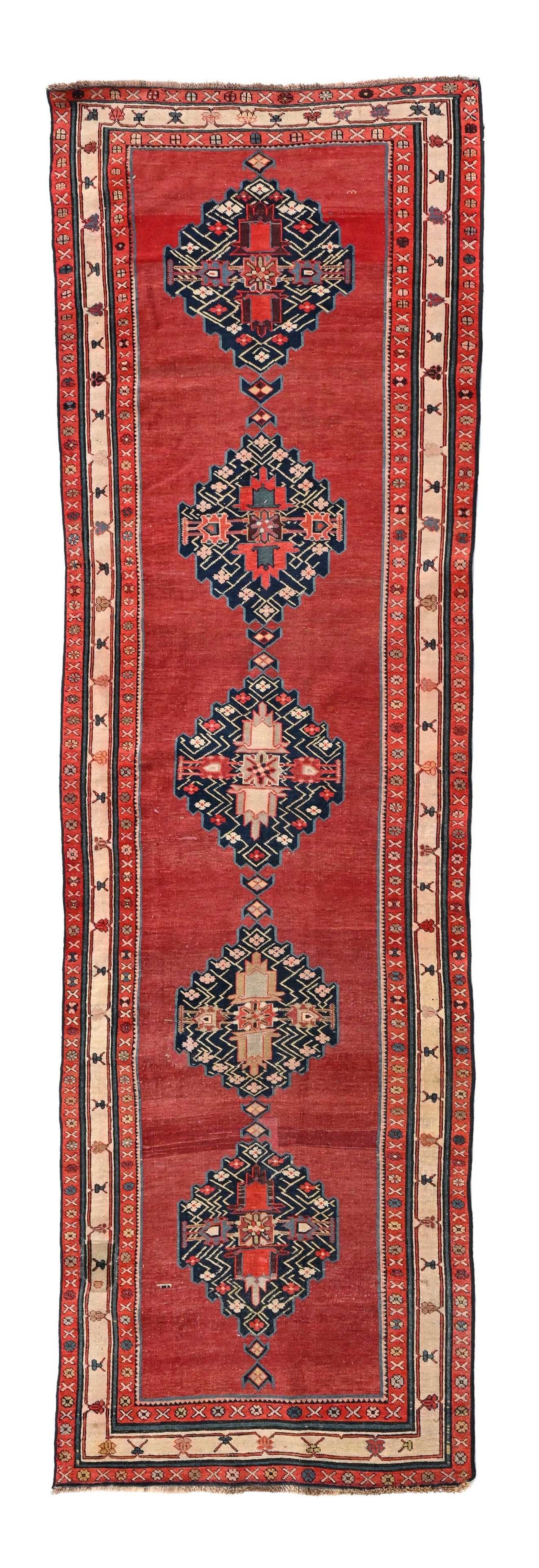 Tapis Karabagh, Caucase, 1er tiers du XXe s., orné d'une rangée centrale de cinq méda: Tapis Karabagh, Caucase, 1er tiers du XXe s., orné d'une rangée centrale de cinq médaillons bleus sur fond uni rouge, multiples bordures à frises de motifs stylisés, 109x328