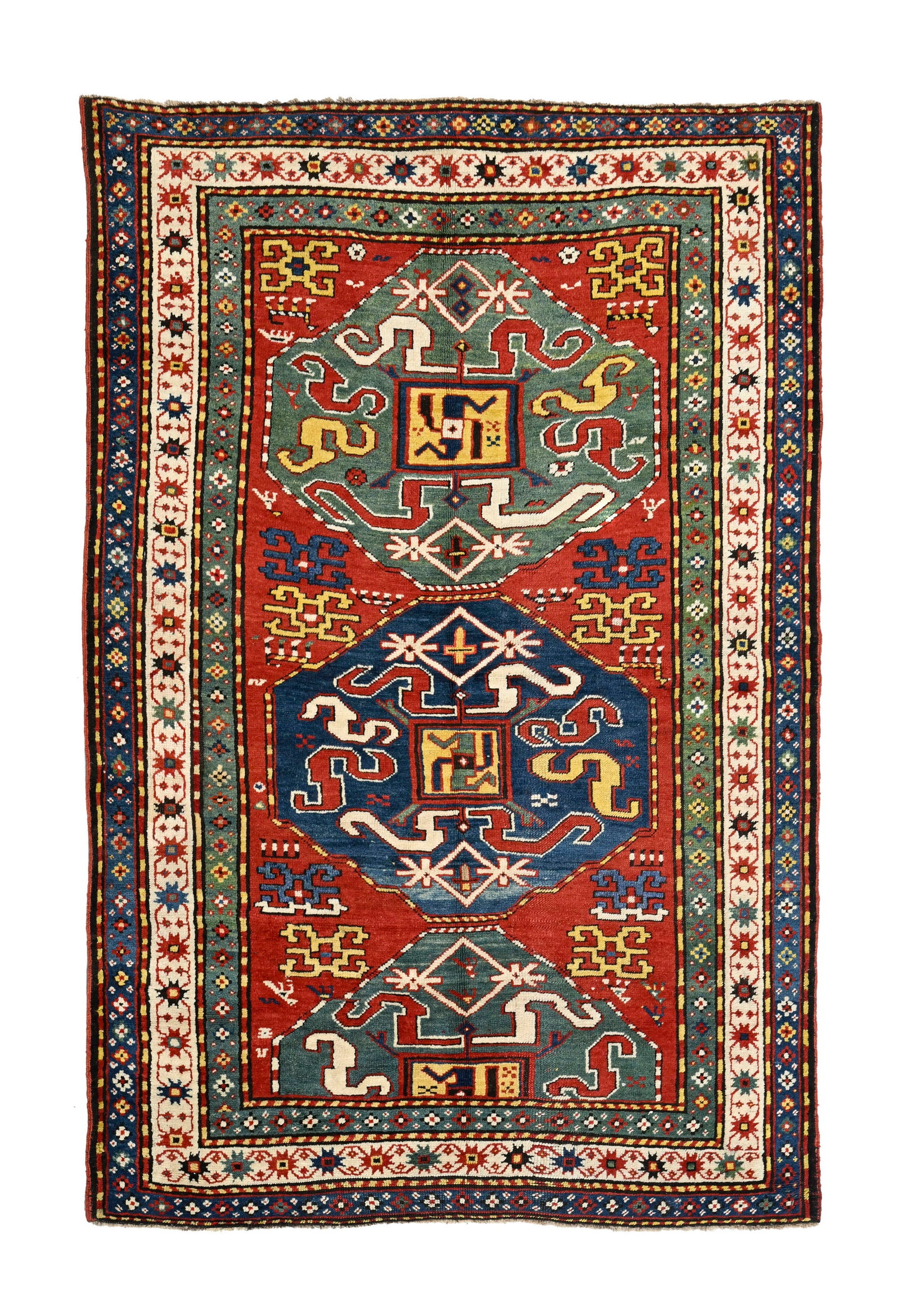 Tapis Kazakh, Caucase, fin XIXe s., à décor de bandes de nuages inscrites dans des grands : Tapis Kazakh, Caucase, fin XIXe s., à décor de bandes de nuages inscrites dans des grands médaillons verts et bleu, fond rouge orné de motifs géométriques, multiples bord