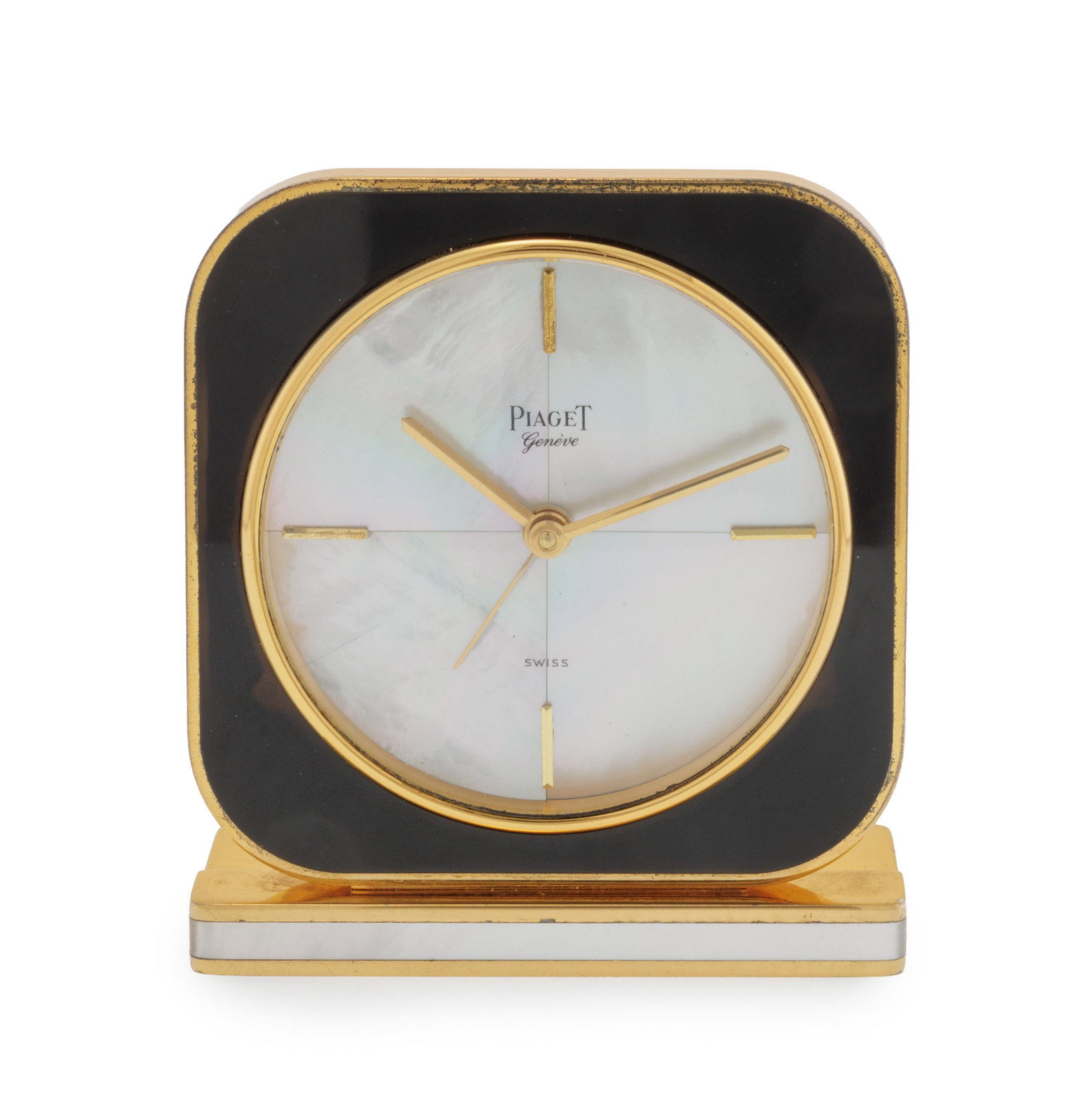 Piaget, pendulette réveil en métal doré ornée de nacre et de résine noire : Piaget, pendulette réveil en métal doré ornée de nacre et de résine noire Mouvement: quartz Boîtier: n°56 1048/1446496, dim. 8.2 x 7.2 cm Complication: alarme Signat
