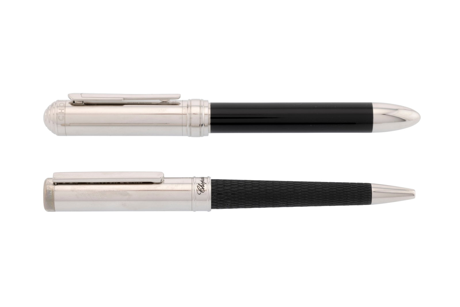 Chopard, lot de deux stylos billes en métal argenté et résine noire, long. 14.4 et 13: Chopard, lot de deux stylos billes en métal argenté et résine noire, long. 14.4 et 13.4 cm Condition Bon état de conservation général. Présence de rayures et de