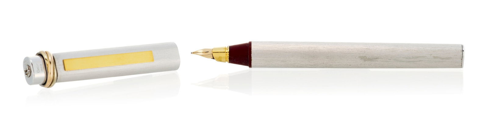 Cartier, un stylo plume en métal doré et argenté, signé, numéroté 9049 - 2