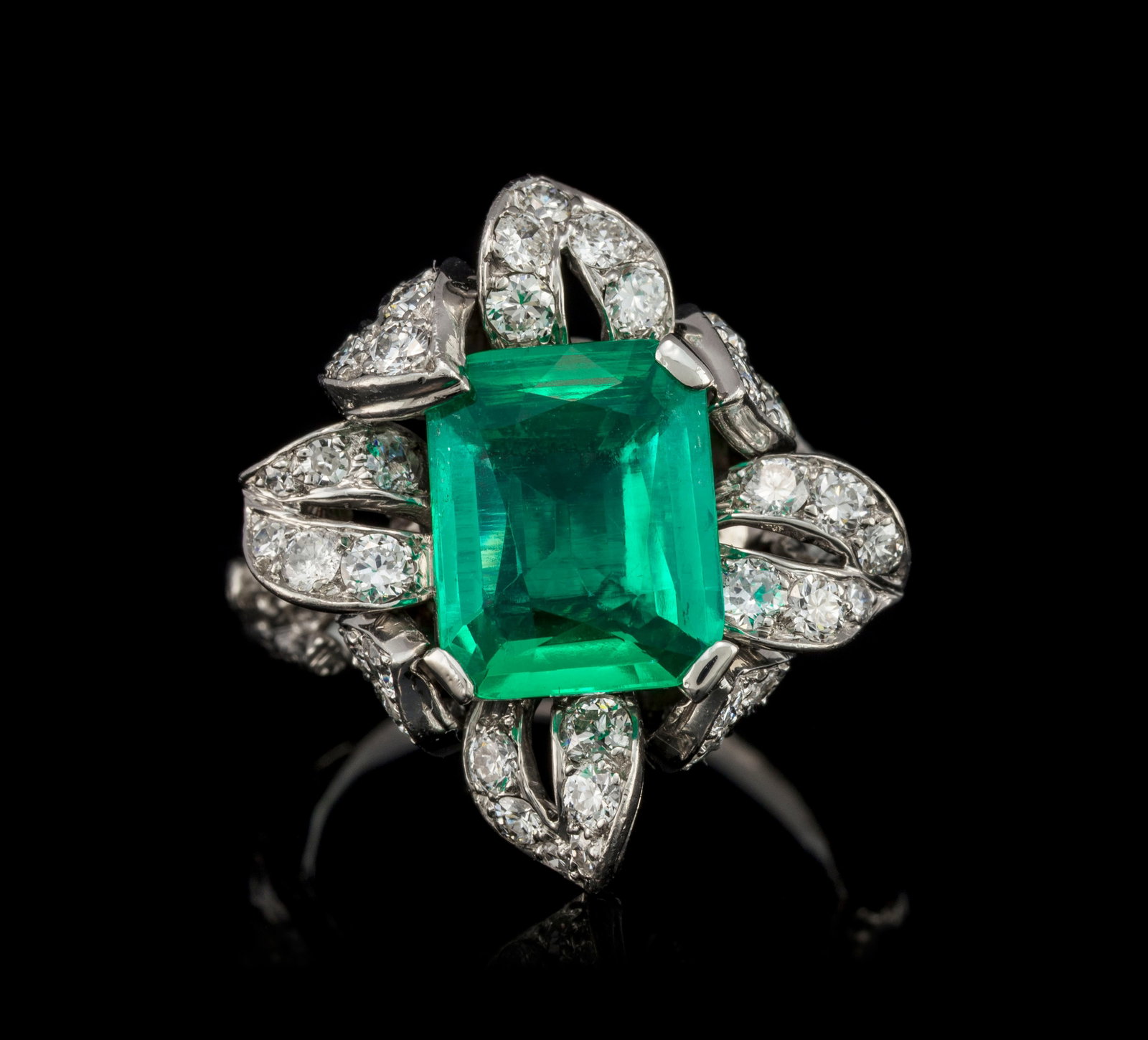 Sterlé, bague années 1950 platine stylisant une branche s'enroulant autour du doigt surmon: Sterlé, bague années 1950 platine stylisant une branche s'enroulant autour du doigt surmontée d'un motif foliacé serti de diamants taille intermédiaire centrant une
