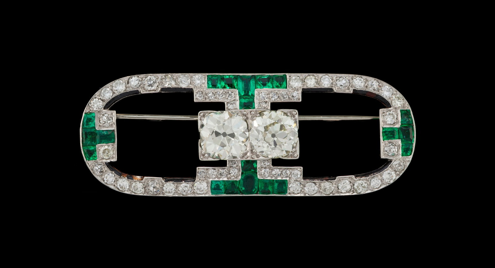 Cartier, broche Art Déco en platine et or gris 750 de forme ovale sertie de diamants taille anc: Cartier, broche Art Déco en platine et or gris 750 de forme ovale sertie de diamants taille ancienne dont deux plus importants (env. 1.9 et 1.8 ct) au centre rehaussés de liserés