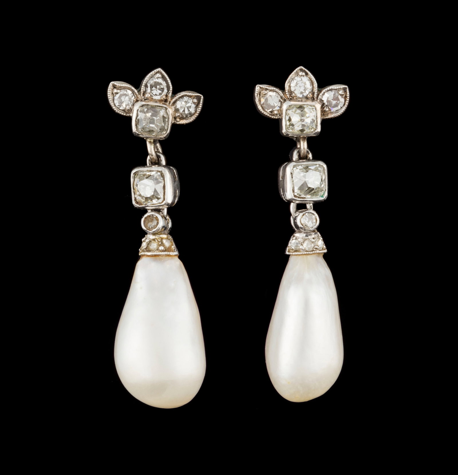 Paire de pendants d'oreilles début XXe s., en platine et or gris 750 sertis de diamants taille : Paire de pendants d'oreilles début XXe s., en platine et or gris 750 sertis de diamants taille ancienne et retenant deux perles gouttes naturelles d'eau de mer selon le rapport GGTL