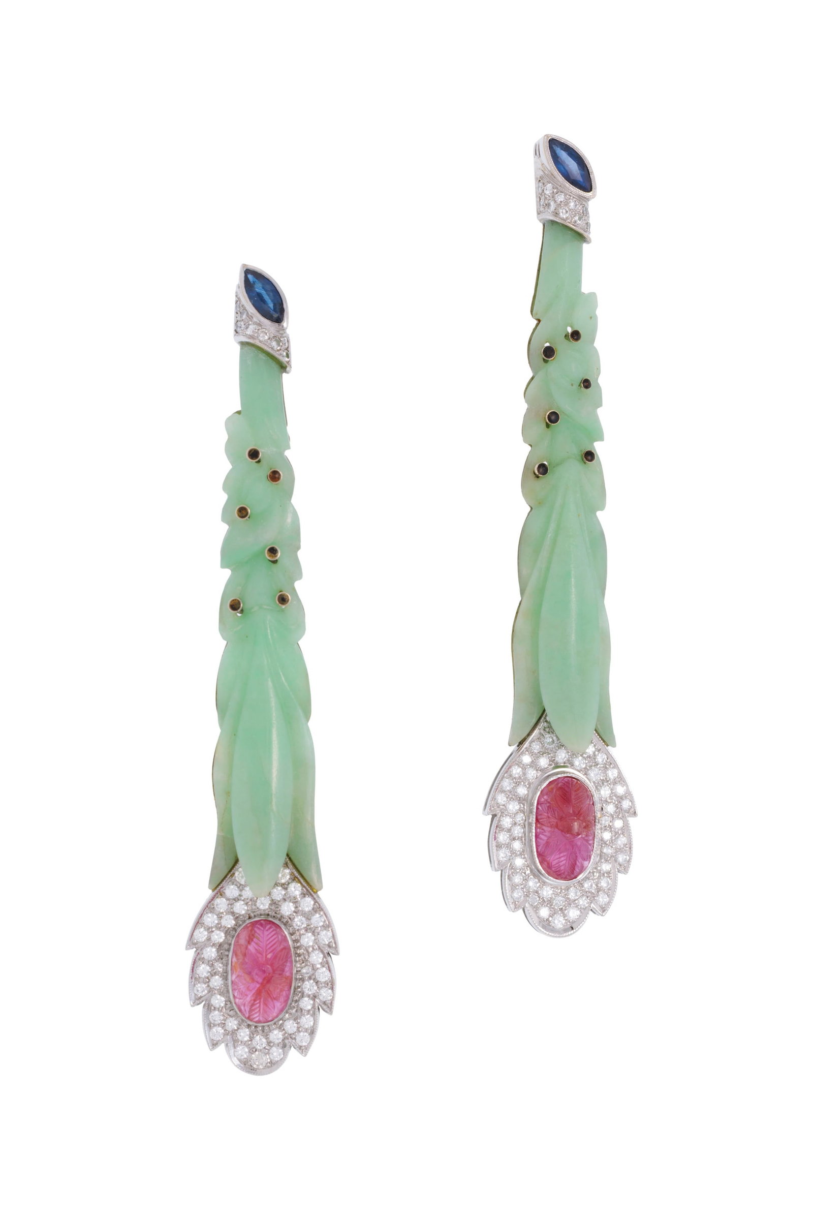 Lot de deux broches or gris 750 formées de deux éléments en jade gravés surmont&: Lot de deux broches or gris 750 formées de deux éléments en jade gravés surmontés de petits points de résine, les extrémités serties de diamants taille