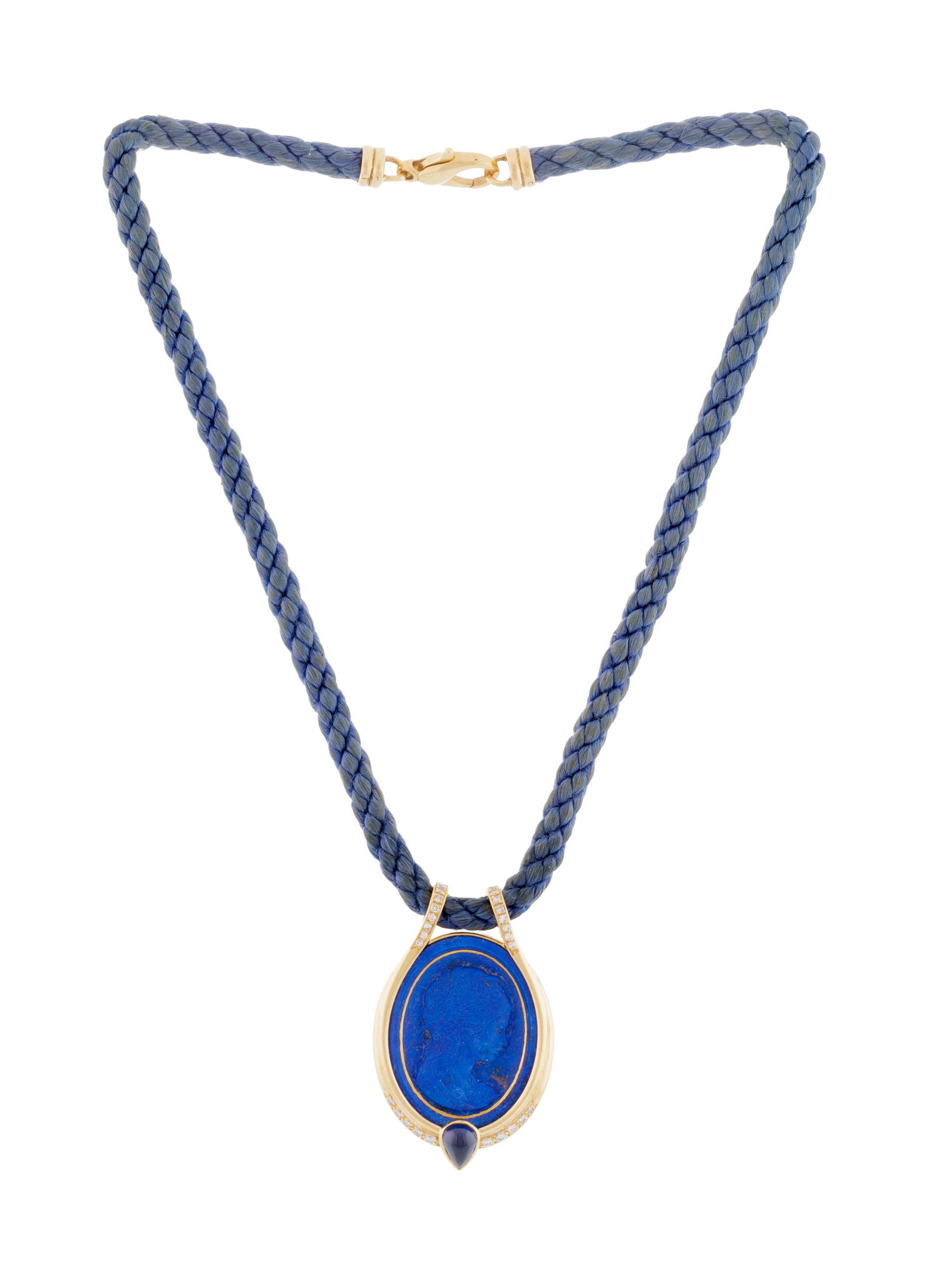 Pendentif or 750 orné d'un camée sur lapis-lazuli représentant un profil féminin: Pendentif or 750 orné d'un camée sur lapis-lazuli représentant un profil féminin entouré d'une goutte de saphir et de diamants taille 8/8, sur un cordon en tissu bleu avec un 