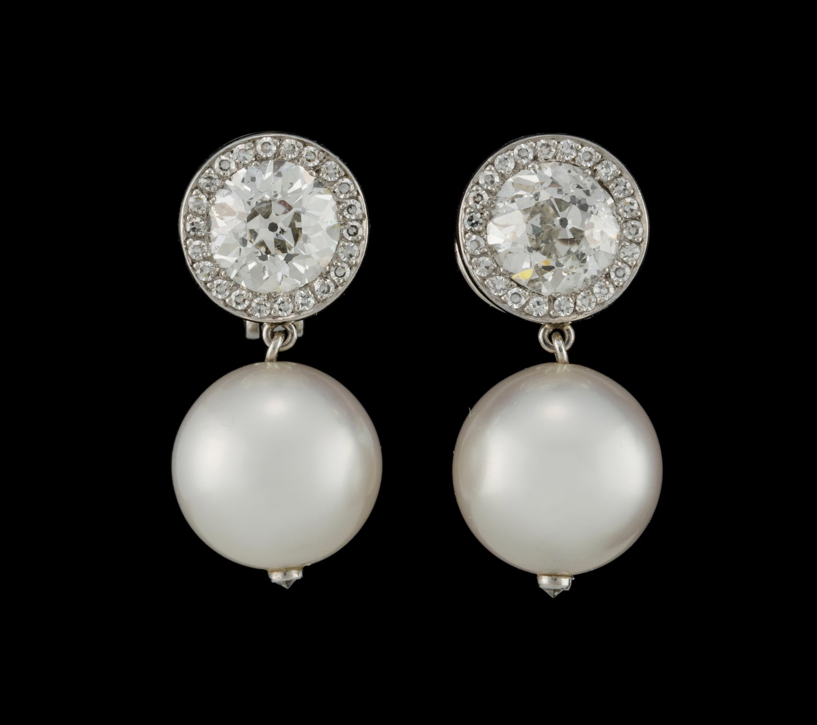 Paire de clips d'oreilles platine sertis de deux diamants taille ancienne (env. 1.8 et 1.7 ct) entou: Paire de clips d'oreilles platine sertis de deux diamants taille ancienne (env. 1.8 et 1.7 ct) entourés de petits diamants taille 8/8 et retenant deux perles de culture blanches, h. 2.5 cm