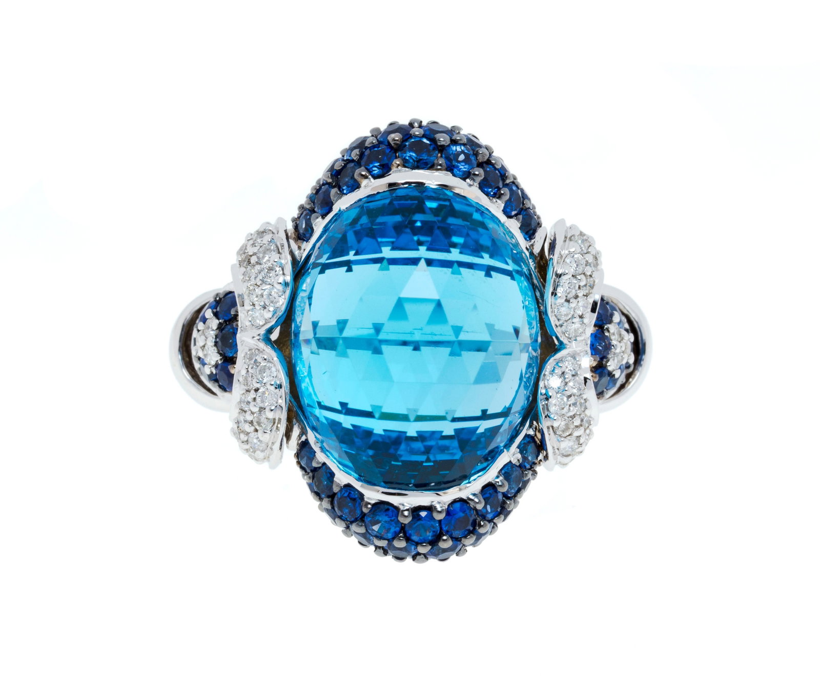 Bague or gris 750 sertie d'une topaze facettée entourée de saphirs et de diamants taille b: Bague or gris 750 sertie d'une topaze facettée entourée de saphirs et de diamants taille brillant, doigt 54-14, 12g Condition Très bon état de conservation général.