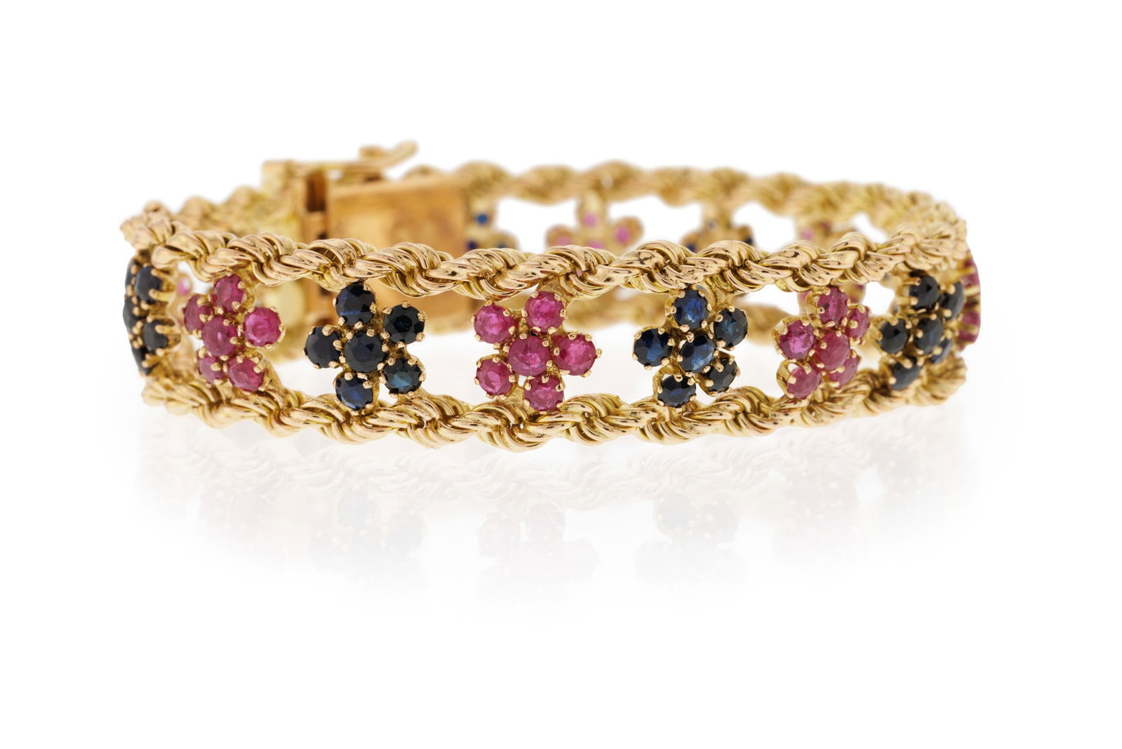 Bracelet or 585 tressé formé d'une rangée de fleurettes serties de saphirs et rubis t: Bracelet or 585 tressé formé d'une rangée de fleurettes serties de saphirs et rubis taille rond, long. 15 cm, 20g Condition Bon état de conservation général.