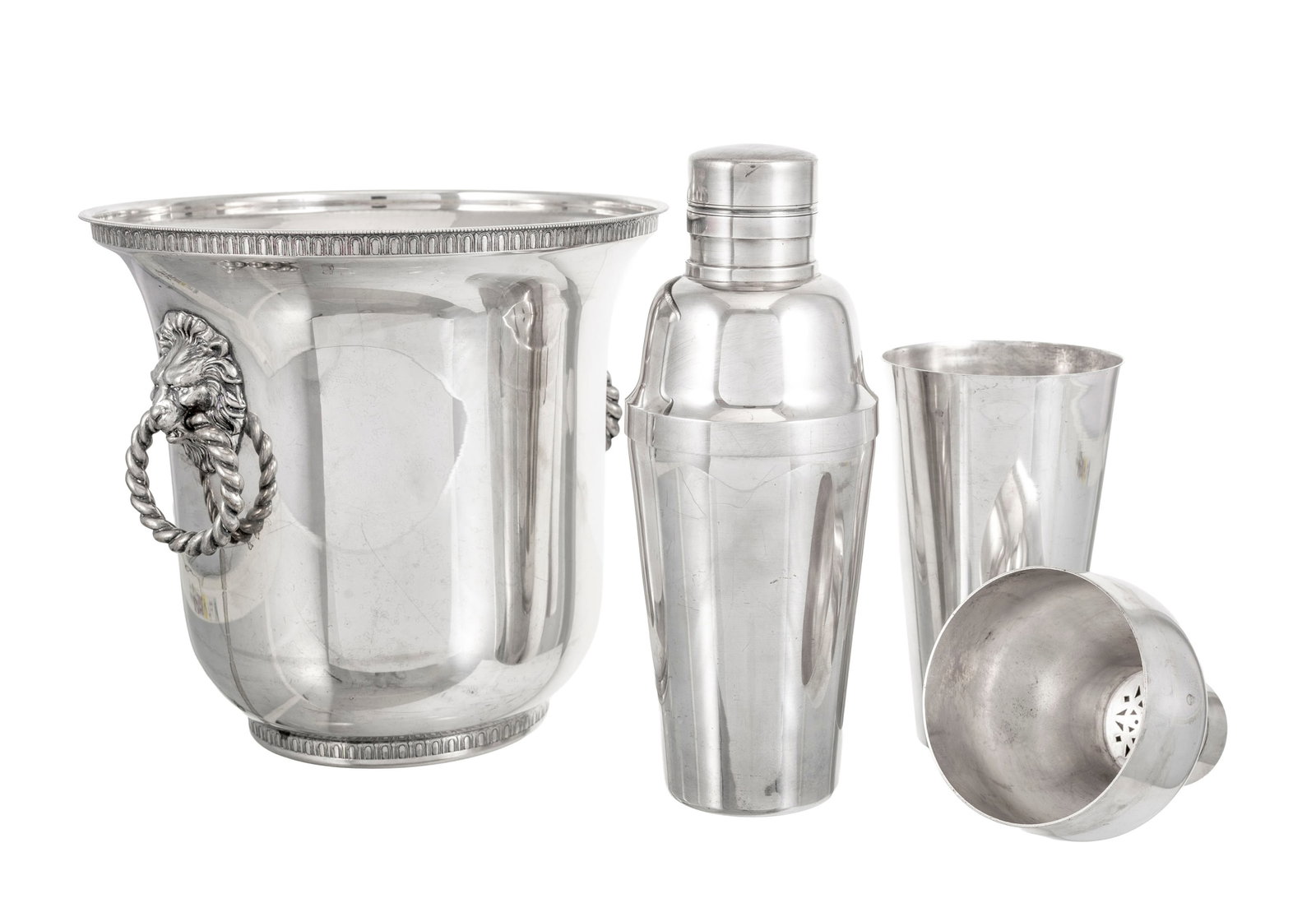 Ensemble de 2 shakers et 1 seau à champagne en métal argenté, XXe s., les anses annea: Ensemble de 2 shakers et 1 seau à champagne en métal argenté, XXe s., les anses anneaux et mufles de lion, h. 20,5, 23,5 et 24 cm Condition 1 bouchon de shaker coincé traces d'u