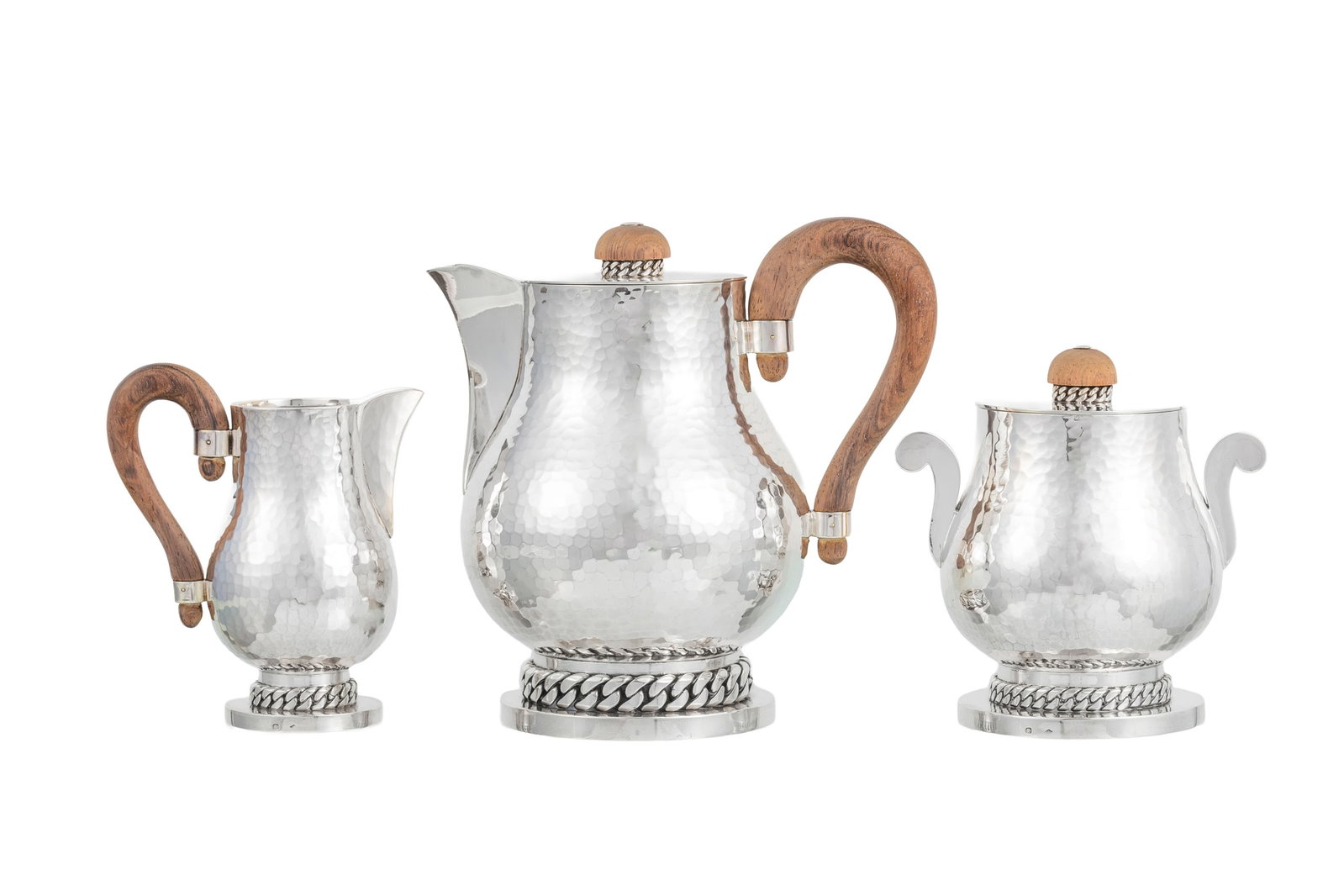 Jean Després (1889-1980). Partie de service à thé en argent martelé Minerve 1er : Jean Després (1889-1980). Partie de service à thé en argent martelé Minerve 1er titre, circa 1950, les anses en palissandre, comprenant 3 pièces: théière,