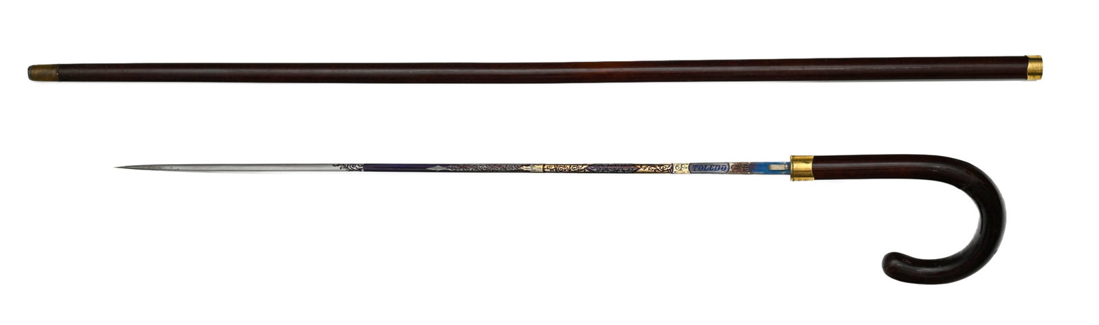 Canne épée à lame de Tolède, fin XIXe s., corps en bois exotique moucheté, : Canne épée à lame de Tolède, fin XIXe s., corps en bois exotique moucheté, lame à décor bleui et doré de rinceaux, long. totale : 92 cm, long. lame : 51 cm Cond