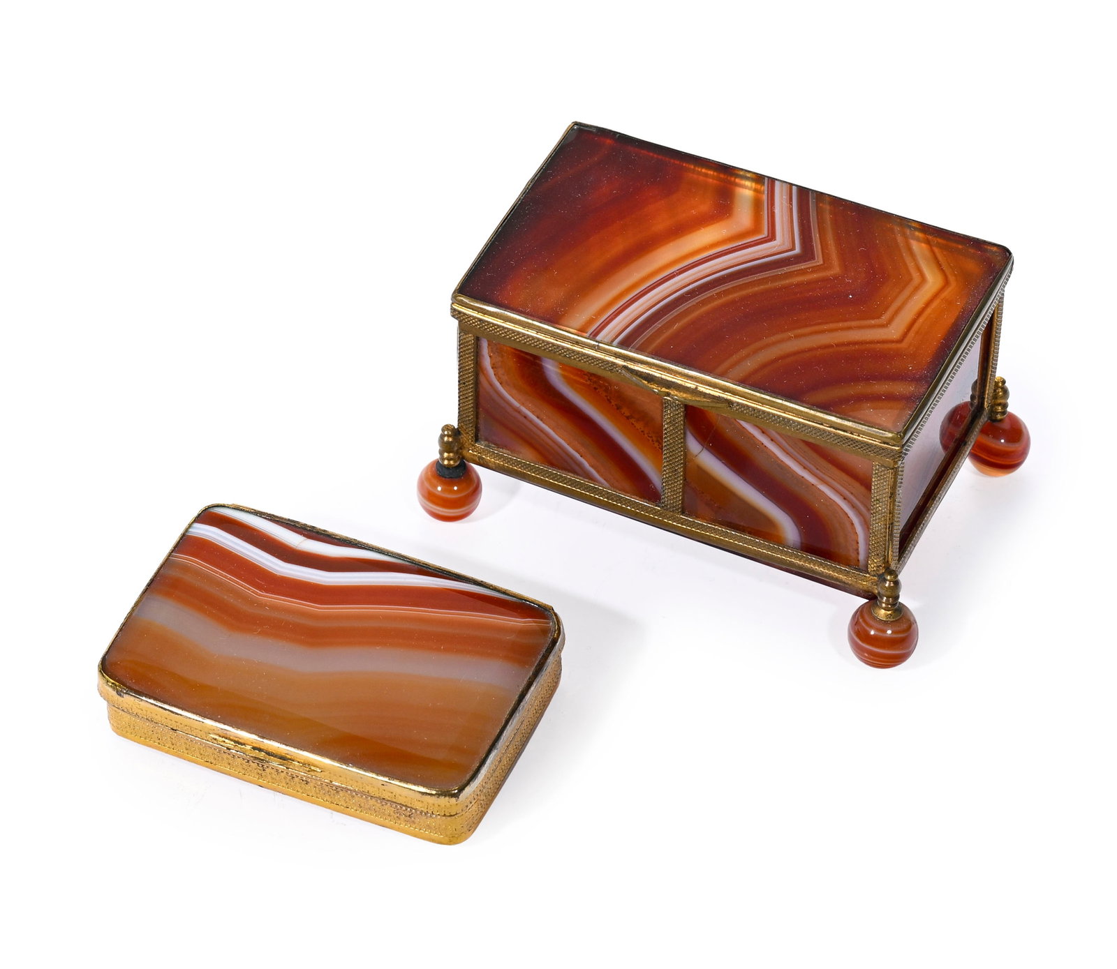 Coffret et boîte rectangulaires en agate rubanée brun-rouge et blanche, XIXe s., montures : Coffret et boîte rectangulaires en agate rubanée brun-rouge et blanche, XIXe s., montures en pomponne, le coffret sur quatre pieds boule en agate, 8x5x6 cm et 6,8x4,8 cm Provenance :