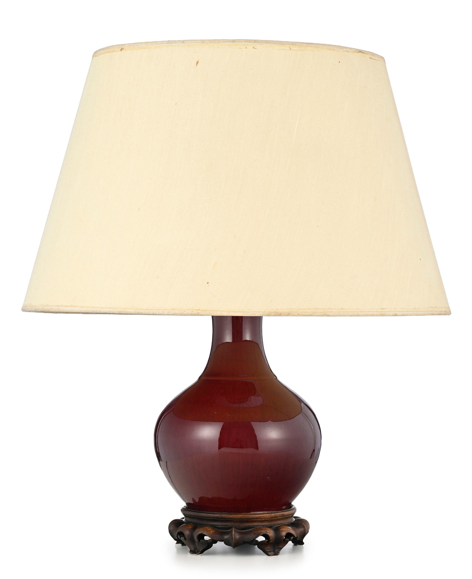 Vase, Chine, XXe s., à glaçure sang de bœuf, abat-jour en tissu beige, base circulair: Vase, Chine, XXe s., à glaçure sang de bœuf, abat-jour en tissu beige, base circulaire en bois sculpté, monté en lampe, h. 61 cm Condition nous ne garantissons pas