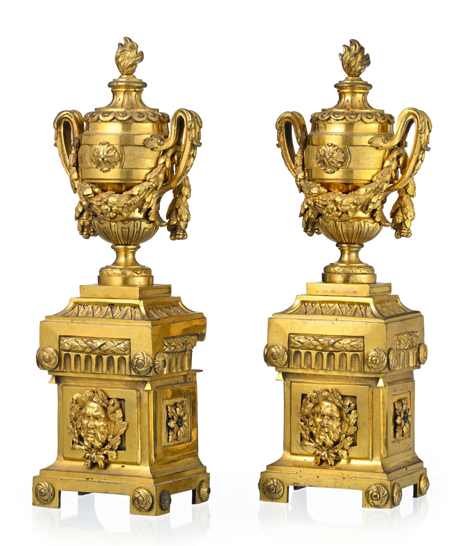 Paire de chenets d'époque Louis XVI, en bronze doré, à décor d'un vase couvert o: Paire de chenets d'époque Louis XVI, en bronze doré, à décor d'un vase couvert orné de guirlandes de feuillages, godrons et terminé par une flamme, base flanquée