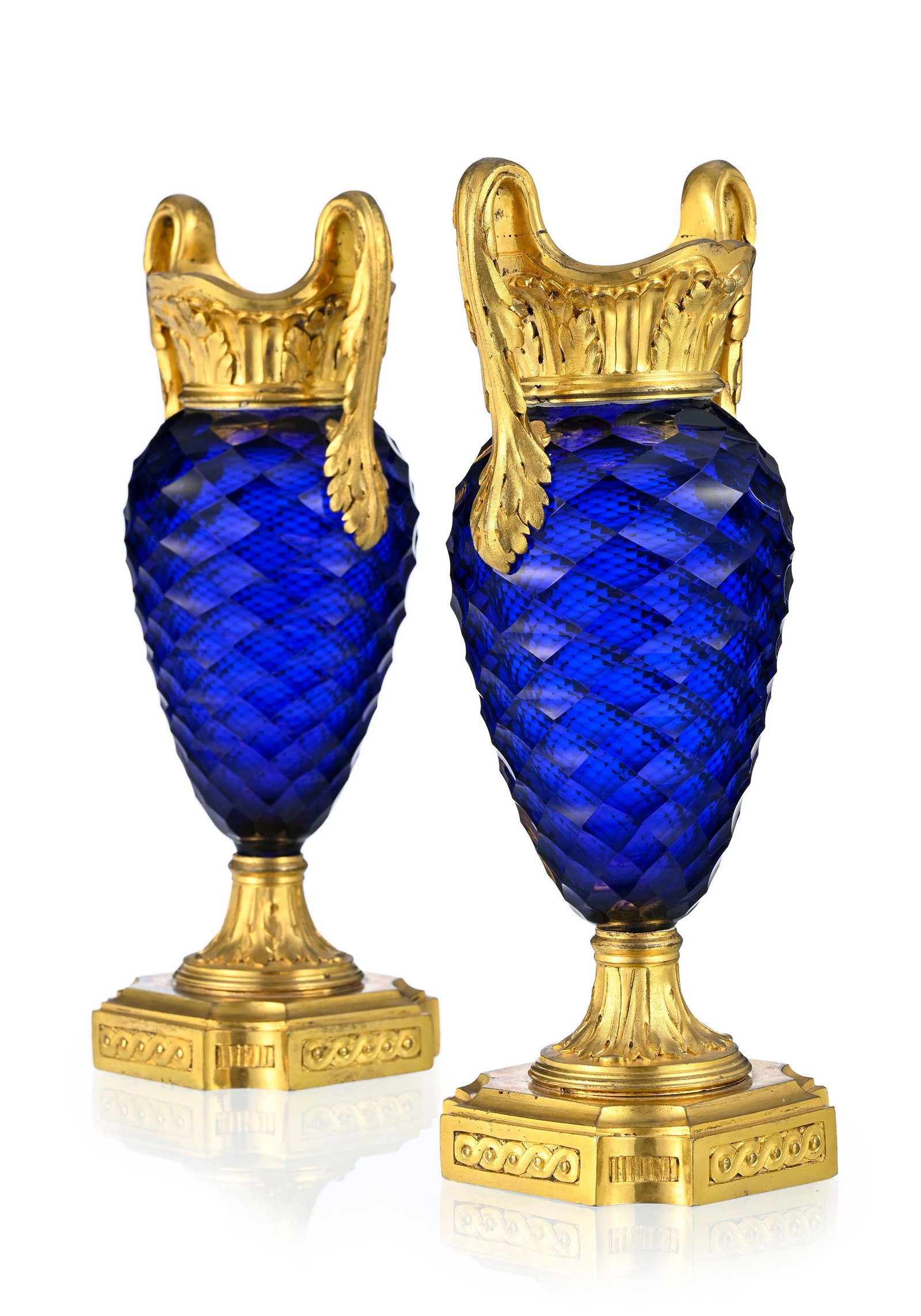 Paire de vases, fin du XVIIIe s., en verre facetté teinté bleu du Creusot, monture en bron: Paire de vases, fin du XVIIIe s., en verre facetté teinté bleu du Creusot, monture en bronze doré à décor de feuilles d'acanthe et entrelacs, h. 29 cm Provenance Au