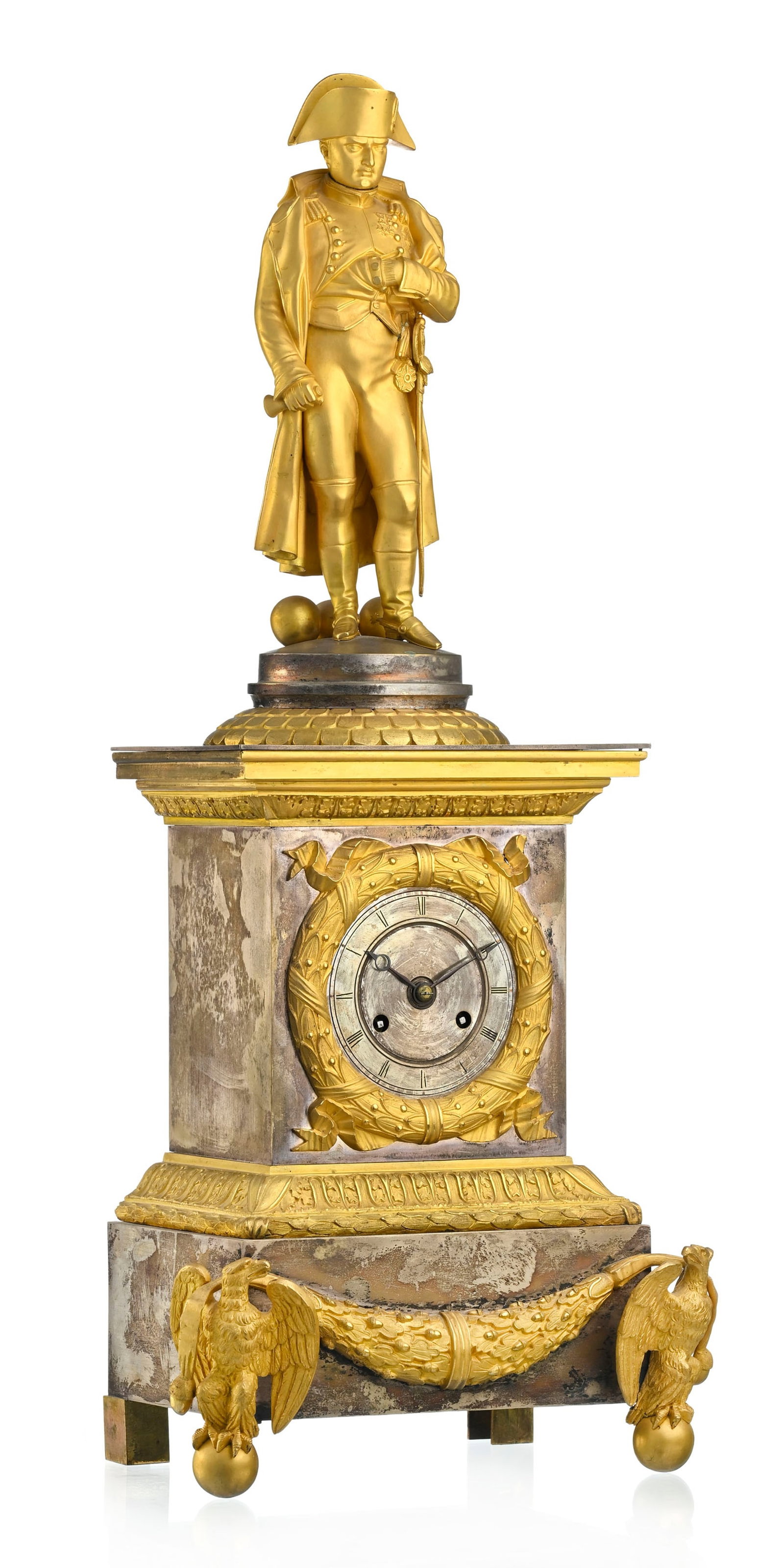 Pendule borne, XIXe s., en bronze doré et argenté, flanqué de Napoléon Bonaparte: Pendule borne, XIXe s., en bronze doré et argenté, flanqué de Napoléon Bonaparte, cadran circulaire ceint d'une frise de lauriers, base ornée de feuilles de chêne et