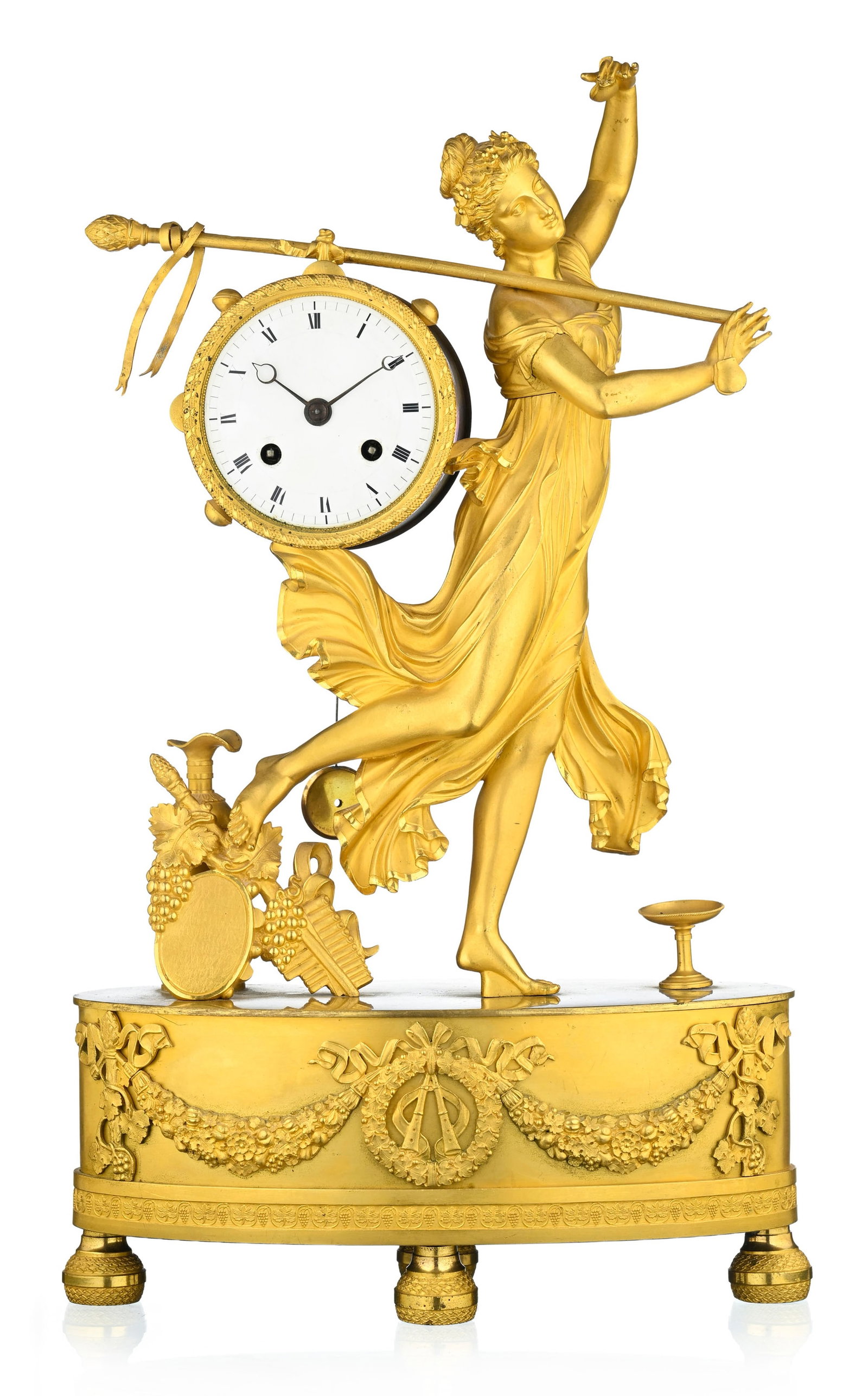 Pendule d'époque Restauration, dite à la Bacchante dansant, cadran circulaire émaill&: Pendule d'époque Restauration, dite à la Bacchante dansant, cadran circulaire émaillé, base ovale ornée de guirlandes de fleurs et reposant sur quatre pieds, 40x24x12 cm