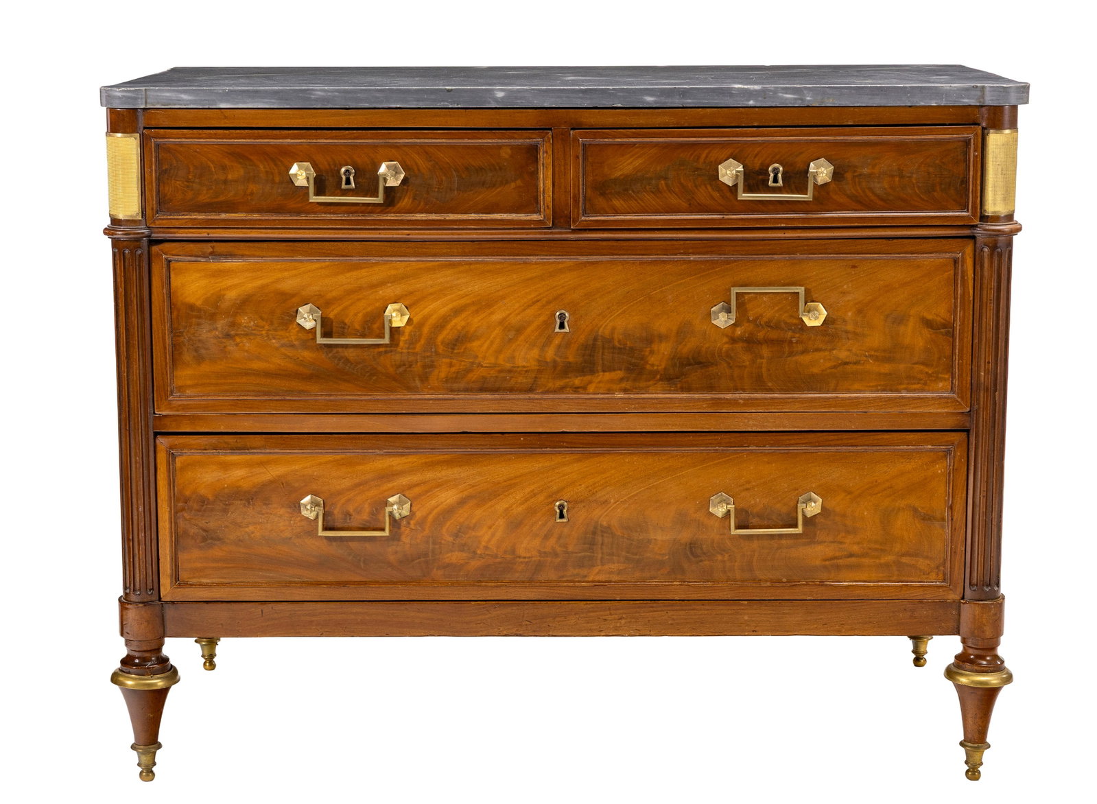 Commode d'époque Louis XVI, en placage d'acajou flammé ouvrant par quatre tiroirs sur troi: Commode d'époque Louis XVI, en placage d'acajou flammé ouvrant par quatre tiroirs sur trois rangs, montants cannelés terminés par des pieds toupies, plateau en marbre gris, 89x113x