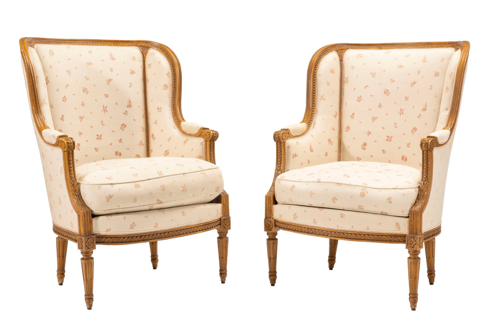 Paire de bergères de style Louis XVI, XIXe s., en hêtre sculpté à décor d'u: Paire de bergères de style Louis XVI, XIXe s., en hêtre sculpté à décor d'une frise de raies de cœur, frises de piastres et feuilles d'acanthe, garniture en tissu beige