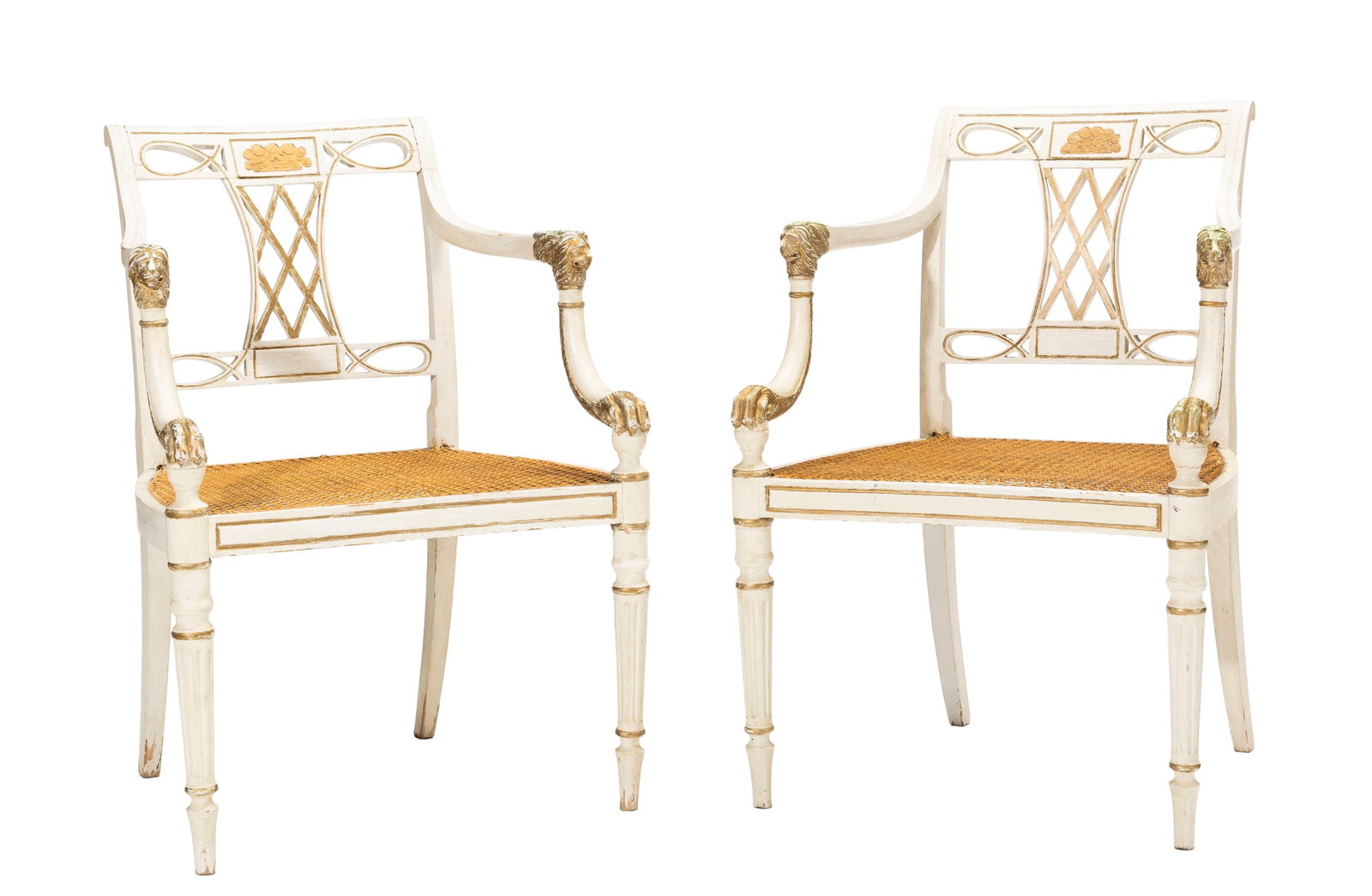 Paire de fauteuils de style Regency, XXe s., en bois peint beige et rehauts dorés, dossier ajou: Paire de fauteuils de style Regency, XXe s., en bois peint beige et rehauts dorés, dossier ajouré, assise cannée, pieds cannelés Condition dégât au cannage d'une assise