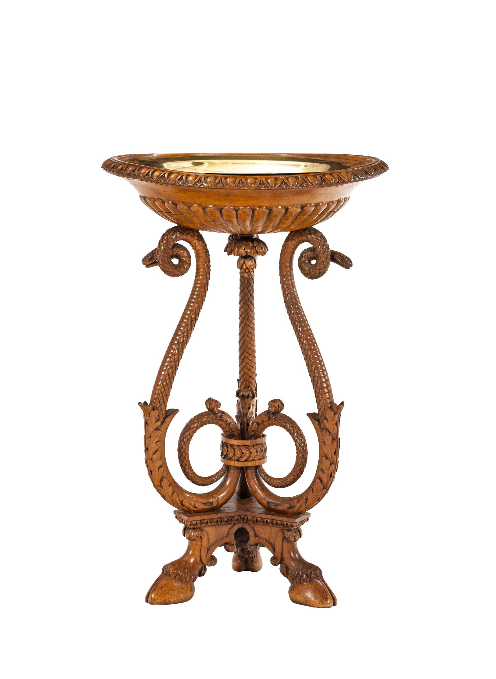 Athénienne, XIXe s., en bois sculpté, montants simulant des serpents et terminés par : Athénienne, XIXe s., en bois sculpté, montants simulant des serpents et terminés par des pieds sabots, plateau en laiton ceint d'une frise de godrons, pieds sabots, h. 76 cm, diam. 49