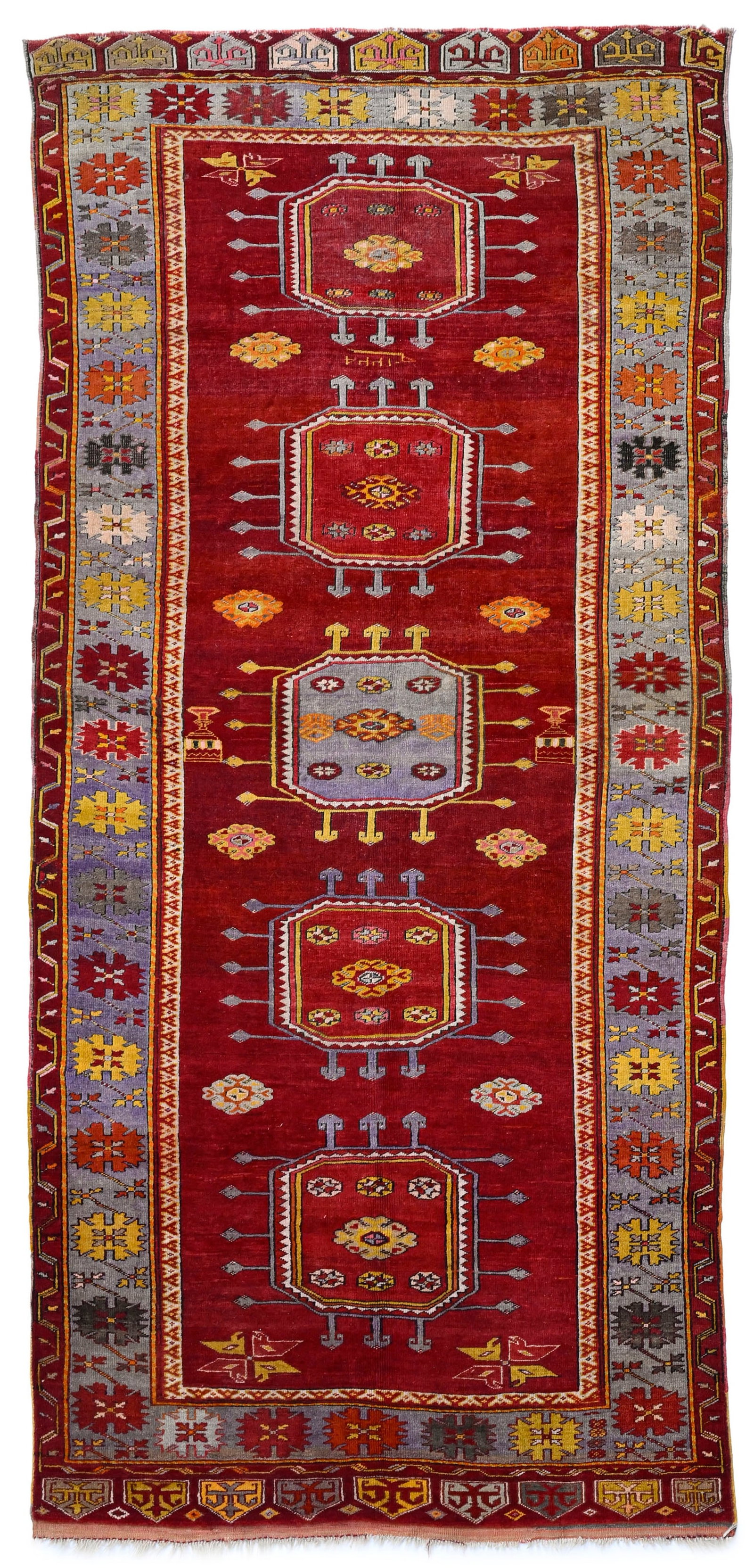 Tapis Bergama, Turquie, 1ère moitié du XXe s., orné d'une rangée centrale de g&#: Tapis Bergama, Turquie, 1ère moitié du XXe s., orné d'une rangée centrale de güls sur fond rouge parsemé de fleurs stylisées, bordure bleue ornée d'une frise