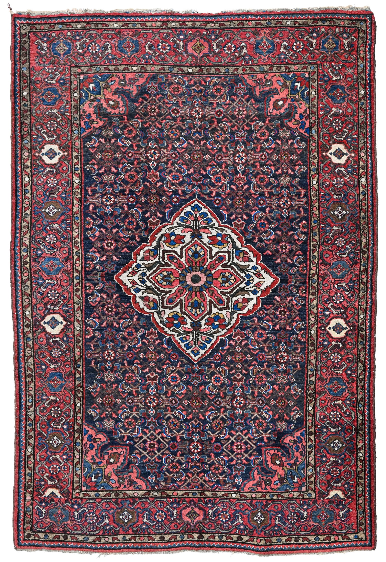 Tapis Hamadan, Iran, milieu du XXe s., à médaillon central beige sur fond bleu marine : Tapis Hamadan, Iran, milieu du XXe s., à médaillon central beige sur fond bleu marine à semis d'un motif herati composé de petites fleurs et feuilles stylisées, bordure rouge 